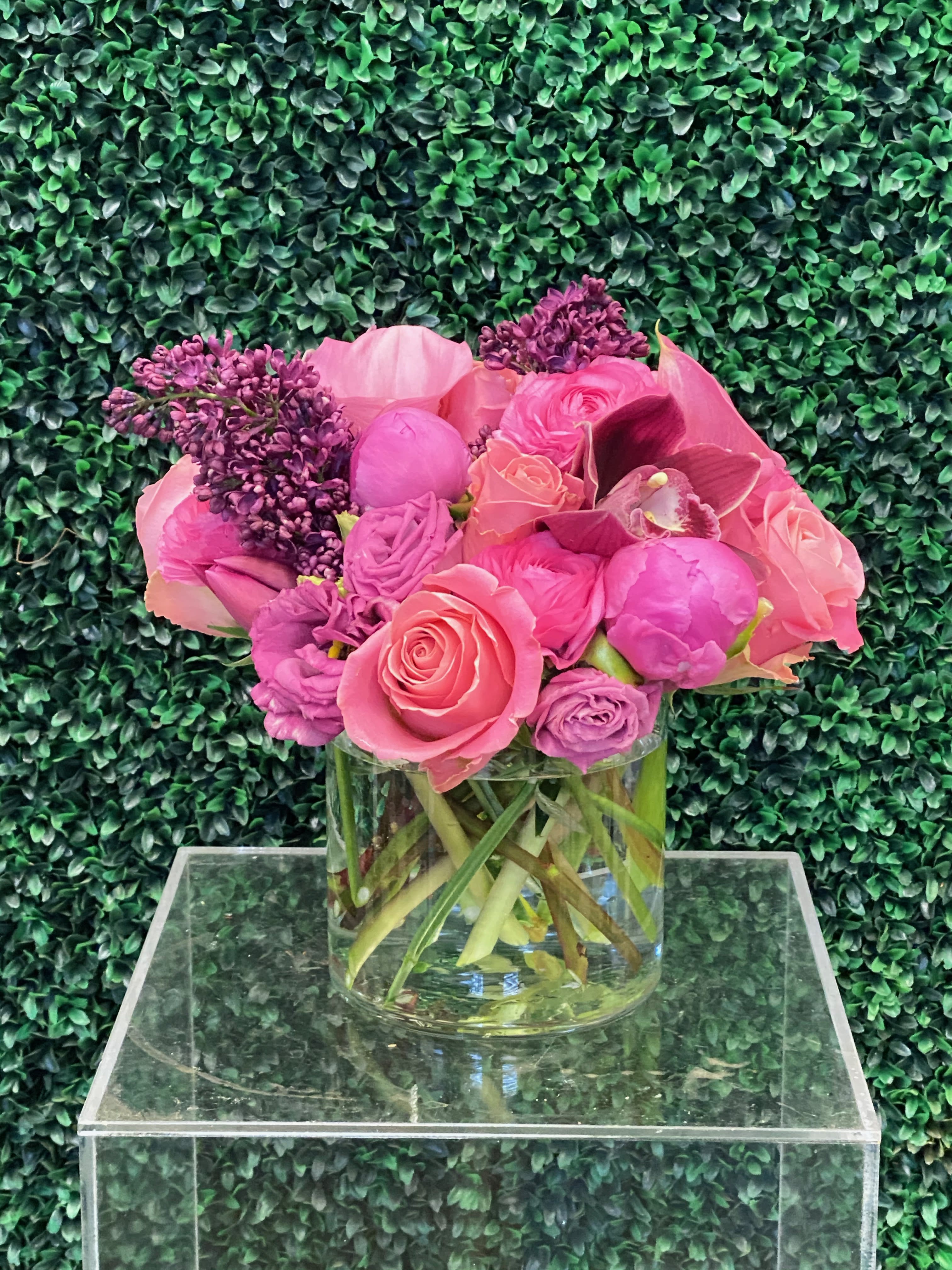 Pink and purple flower arrangement in a clear glass vase