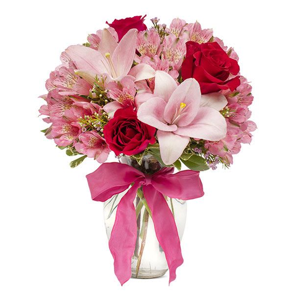 European Romance - his flirtatious combination of Asiatic lilies, waxflower, alstroemeria and roses makes a thoughtful gift they’ll not soon forget. A pretty pink ribbon and clear rose vase add to the romantic look.