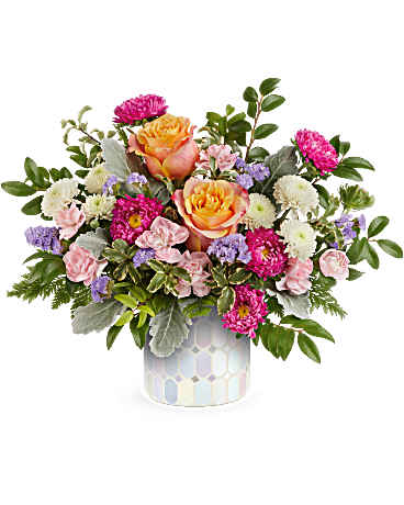 Mixed bouquet of pink, peach, white, and purple flowers in a patterned vase