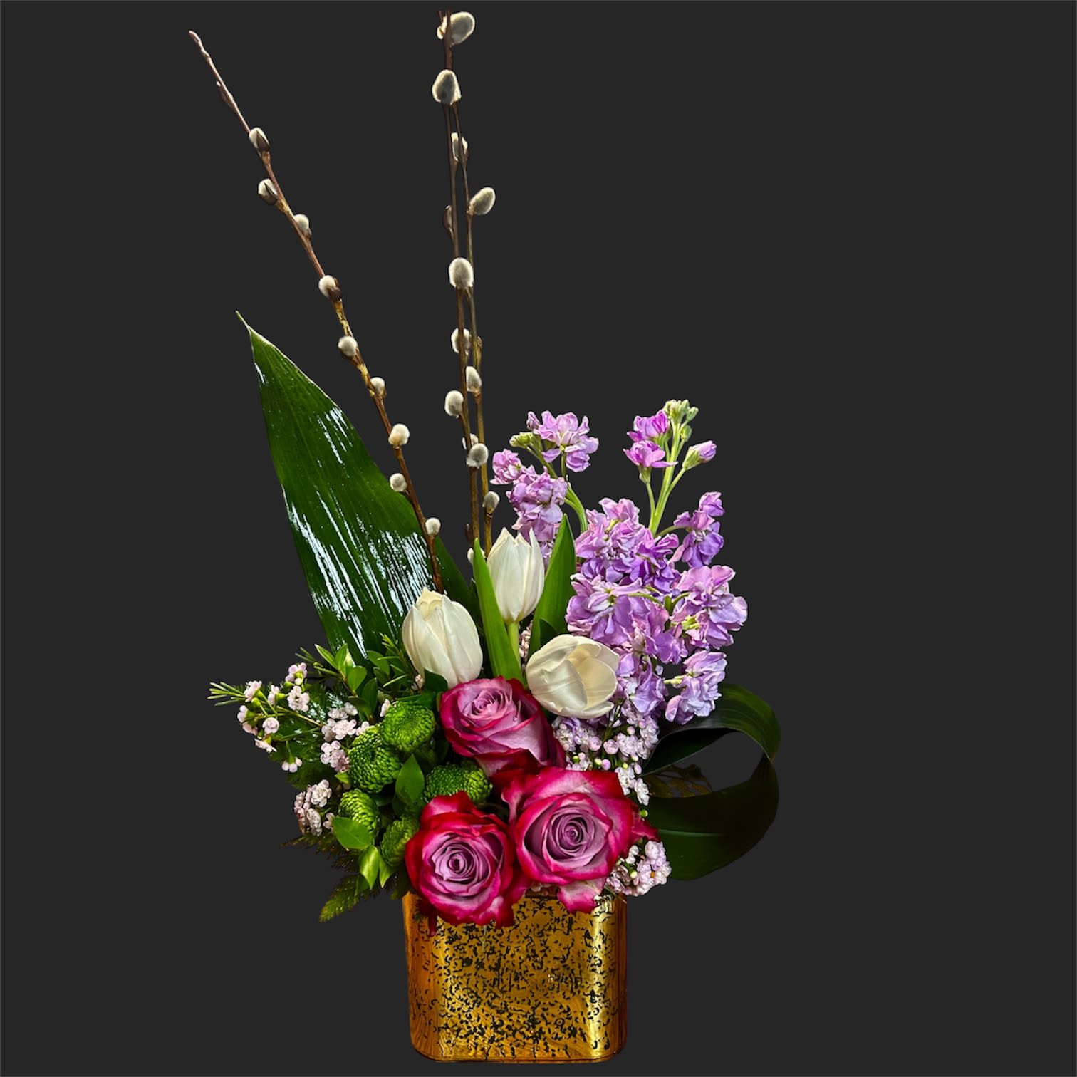 A Touch of Spring  - Hot pink roses meet creamy white tulips and soft lavender stock in a springlike flower arrangement that reads both romantic and refined - perfect as a birthday bouquet, anniversary gift, or Mother's Day surprise. Tall pussy willow branches arch above the blooms to create a sculptural, eye-catching silhouette so the person you're celebrating feels noticed from across the room.