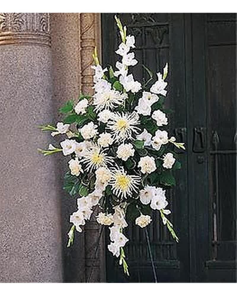 Standing spray of white gladiolus, carnations, and spider mums on an easel.