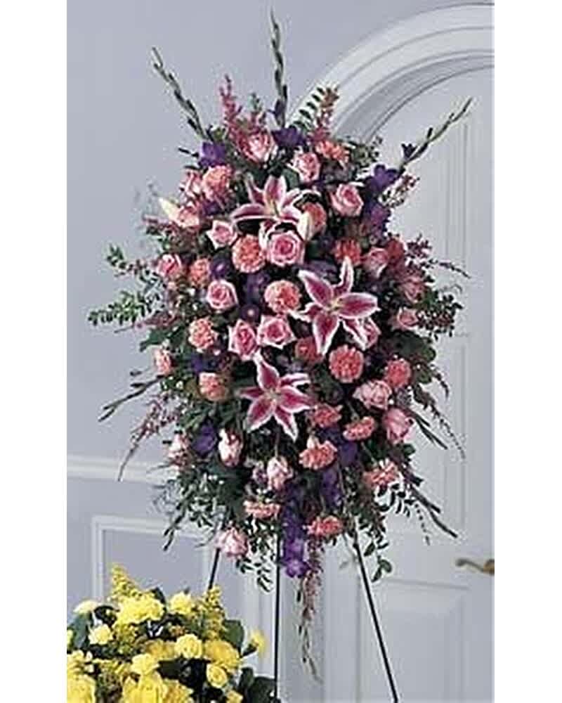 Tall pink and purple standing spray with lilies, roses, and carnations on a metal easel