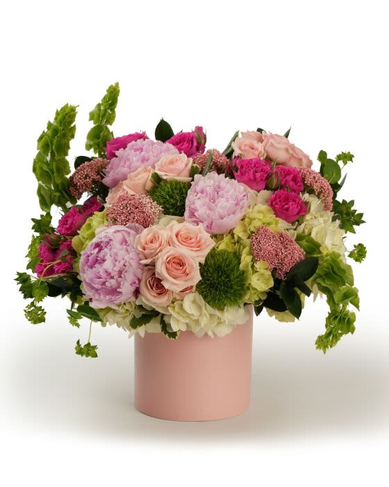 Peony Abundance - An abundant mix of peonies and fresh blooms in layered pink hues, arranged with flowing greenery for a lush garden feel.