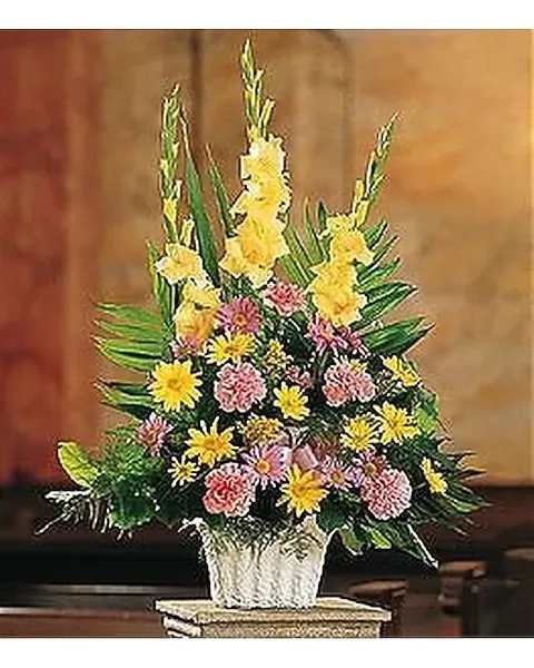 Fan Shape in Mache - This pastel arrangement will express your sympathy and lovingly show your warm thoughts. One arrangement with pink carnations, yellow and lavender daisies, and yellow gladioli, along with a pink ribbon, is delivered in a white container. 