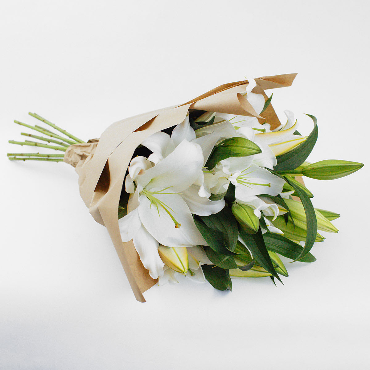 Casa Blanca Lily Bunch - WHITE CASABLANCA LILY BOUQUET  Simple and elegant. A beautifully elegant bouquet of fragrant white Casablanca lilies in a natural kraft paper gift wrap. We let these popular flowers speak for themselves. Casablanca lilies in a vase with no other adornments are sophisticated and timeless. This lily bouquet is perfect for people who embrace understated elegance and classic styles.  Send this beautiful Casablanca lily bouquet to say happy birthday, congratulations or thank you. They also make a lovely sympathy flower gift.  Why not add a greeting card, bunch of local dried lavender or quality handmade candle to match the occasion or personality?  Casablanca Lily Bunch features: ·        10 stems of white Casablanca lilies ·        Natural kraft paper gift wrap  SIZE: The STANDARD flower arrangement is approximately 14” height and 14” width.   ALLERGY ADVICE: This design has high pollen (we recommend people with allergies remove the pollen stamens) and has a strong fragrance. Lilies are known to be poisonous if ingested by cats.     FAQ Q: What time will my flowers arrive and what if no-one is there to accept them? A: Excellent question! We’re unable to provide or guarantee specific delivery times. All our flowers are delivered anytime between 9-5pm, with exception to Sympathy designs for a funeral service. For full details around our delivery process and timings, please see our Terms and Conditions. Q: What days do you deliver flowers? A: All our flowers are available for San Francisco and Daly City delivery seven days a week, between 9am-5pm. Q: May I order for the same day delivery? A: Yes, same day deliveries are available if you place an order before 1pm. Q: May I request to change the design a bit? A: Yes, please make a note in the SPECIAL INSTRUCTION box when you place your online order. We will do our best to follow them. Q: Will my flowers look exactly as what is pictured? A: Yes, although the number of closed buds to open flowers may vary depending on availability on day of delivery.   Ready to bring floral beauty into someone’s world with our fresh white lily bouquet? Order this gift online now or give us a call on (415) 752-2060 if you have a question or special request. 
