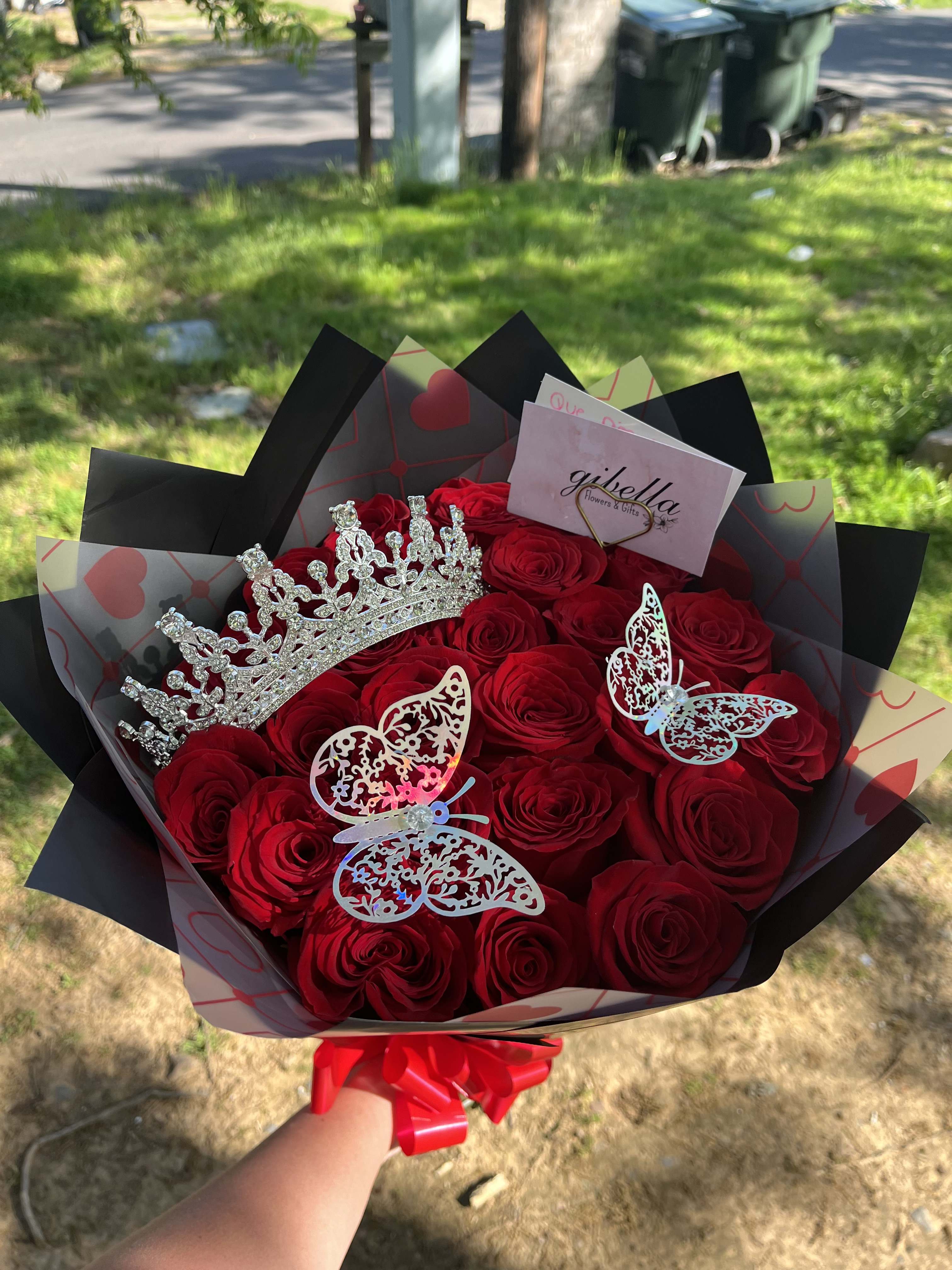Bouquet of red roses with a jeweled crown and butterfly decorations