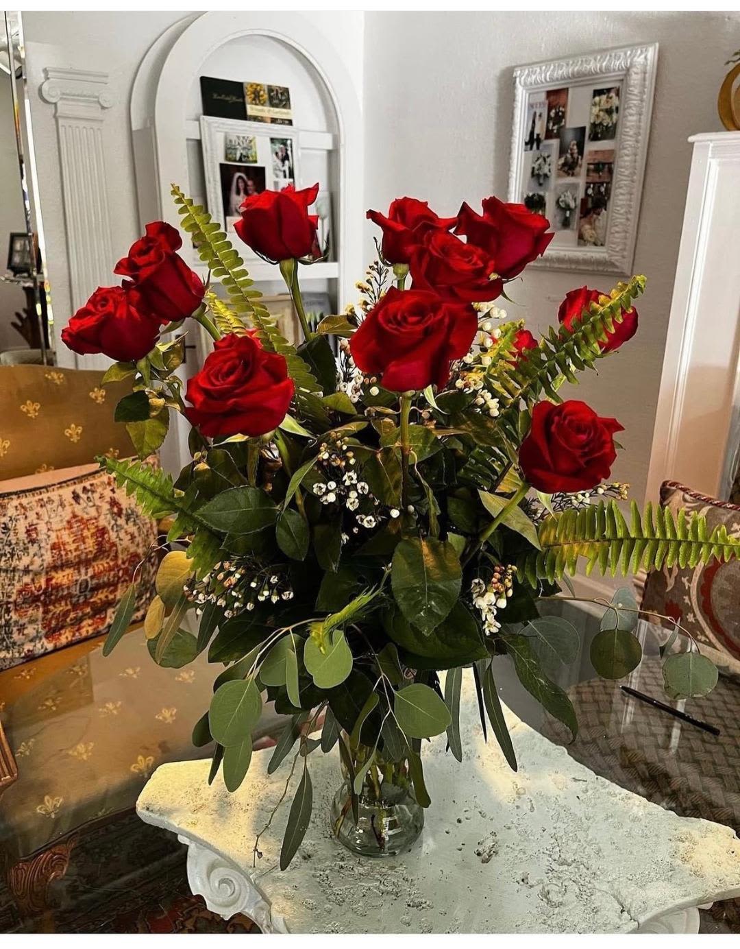 Tall bouquet of red roses in a clear glass vase