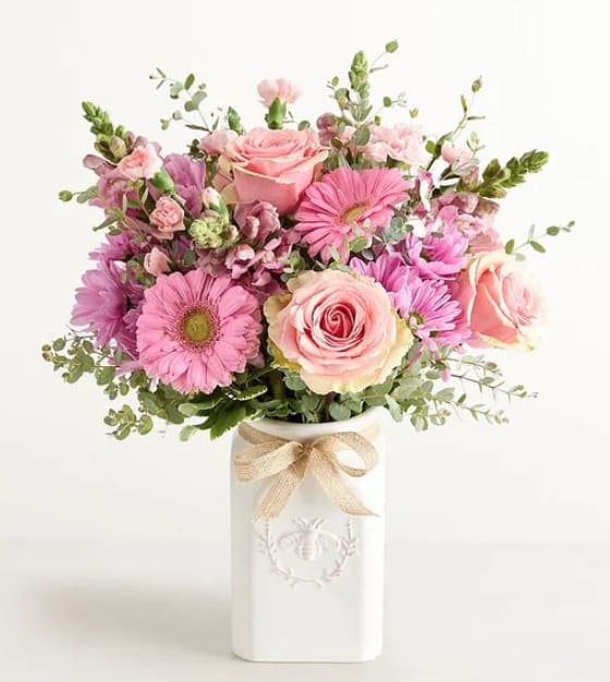 Honey Bee Buzz MOM DAY - Get them buzzing! A glorious mix of blooms in shades of pink and lavender, our eye-catching bouquet dazzles with color and texture. Designed in our Sweet As Can Bee artisanal vase, featuring an adorable honeybee, and accented with a raffia bow, it’s a gift that adds charm and beauty to any decor.