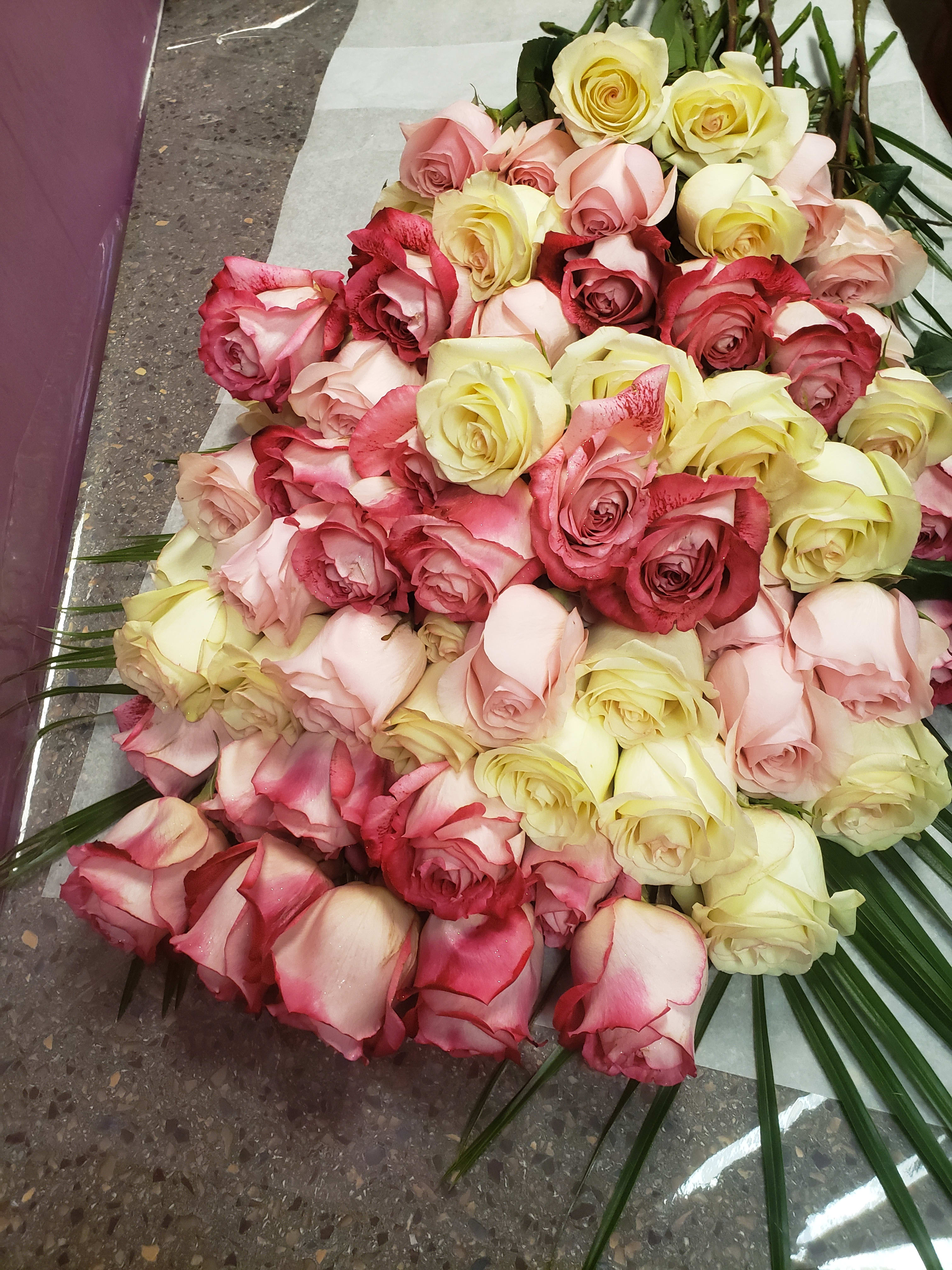 Large bouquet of pink, red, and pale yellow roses