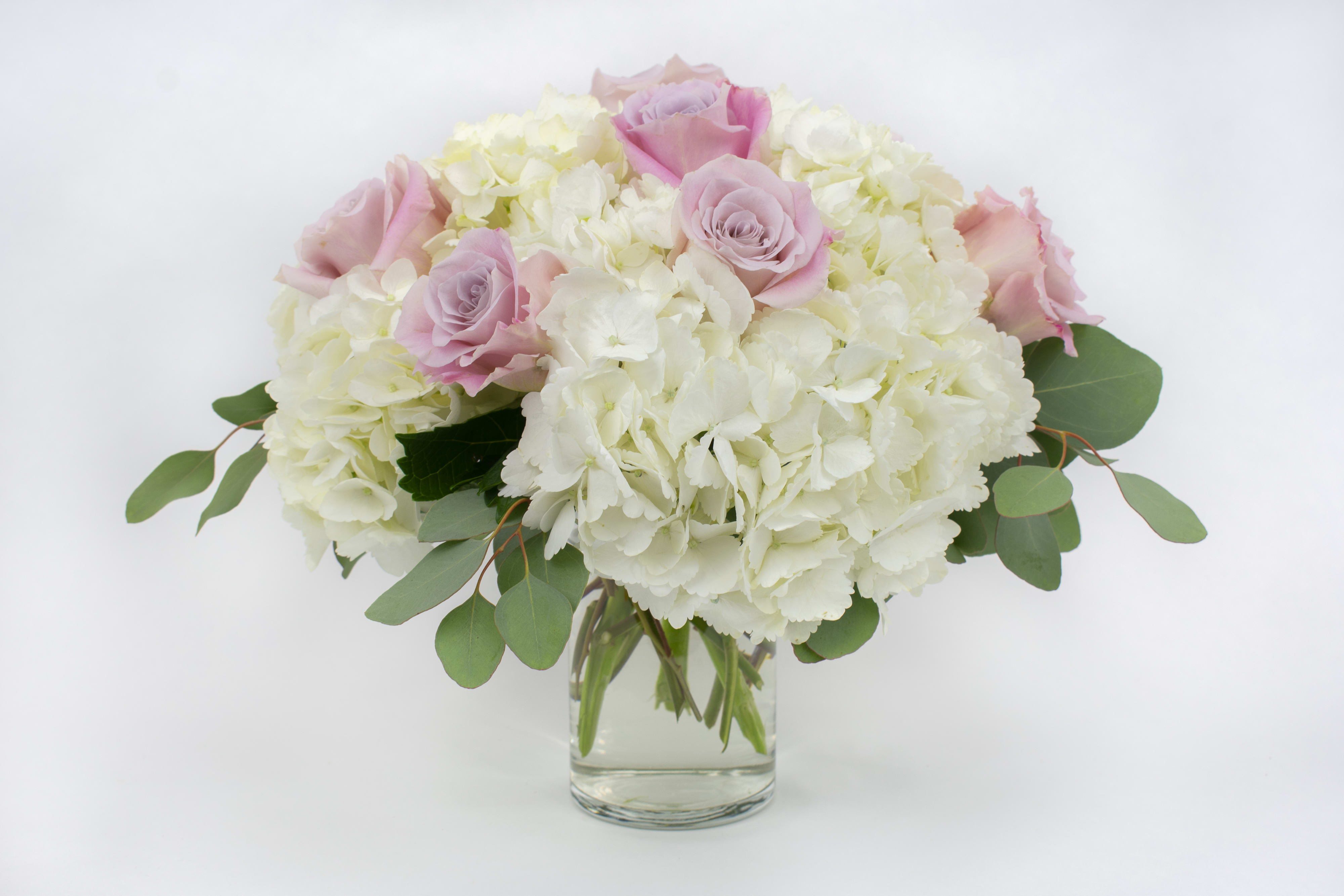 Pink roses and white hydrangeas in a clear glass vase