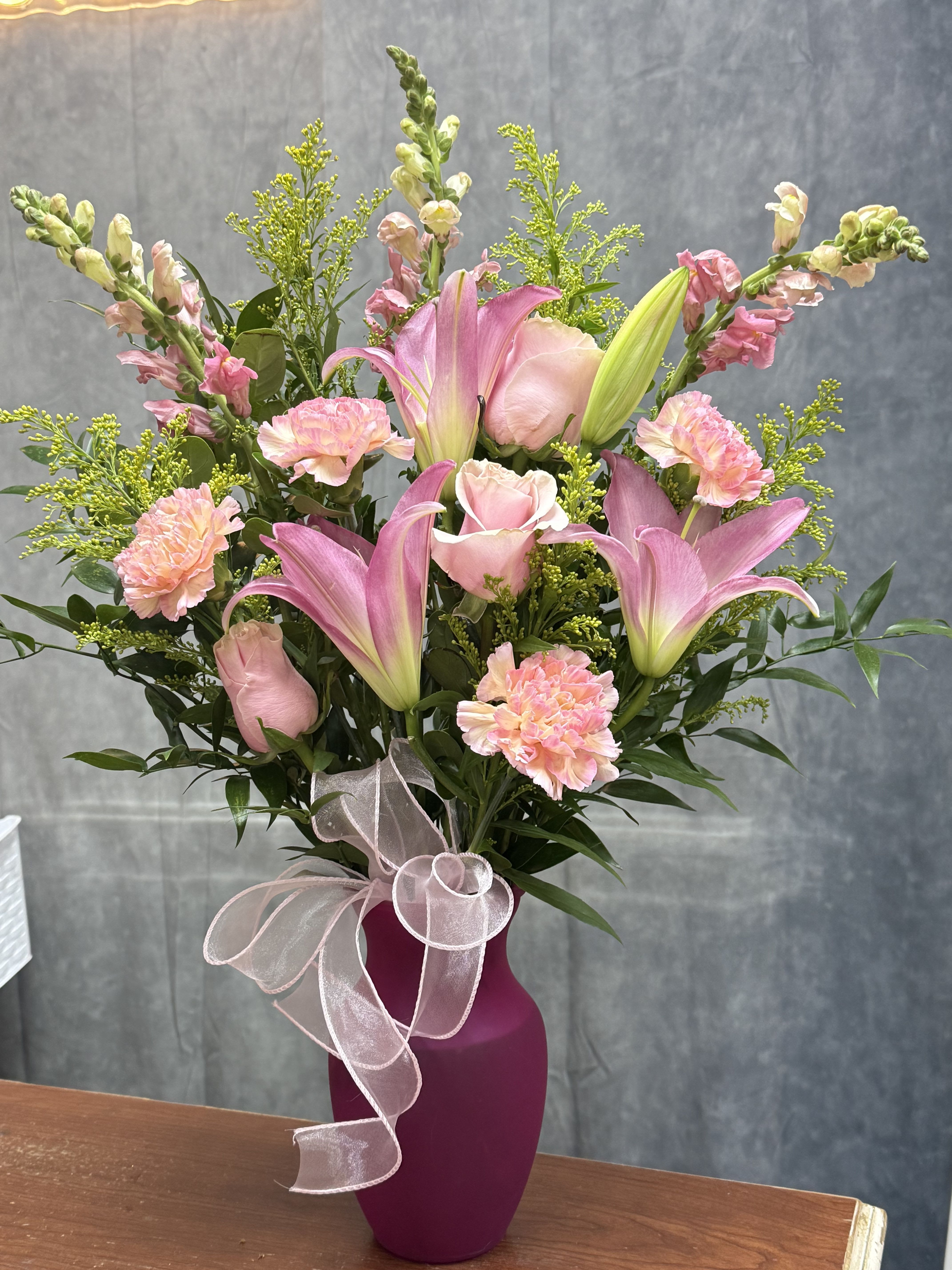 Pink lovers vase - Pink lilies, roses, carnations, and snapdragons in pink shades with fillers  and greenery , arranged in a pink  vase with ribbon-cheerful, perfect  gift for birthdays or spring celebrations.