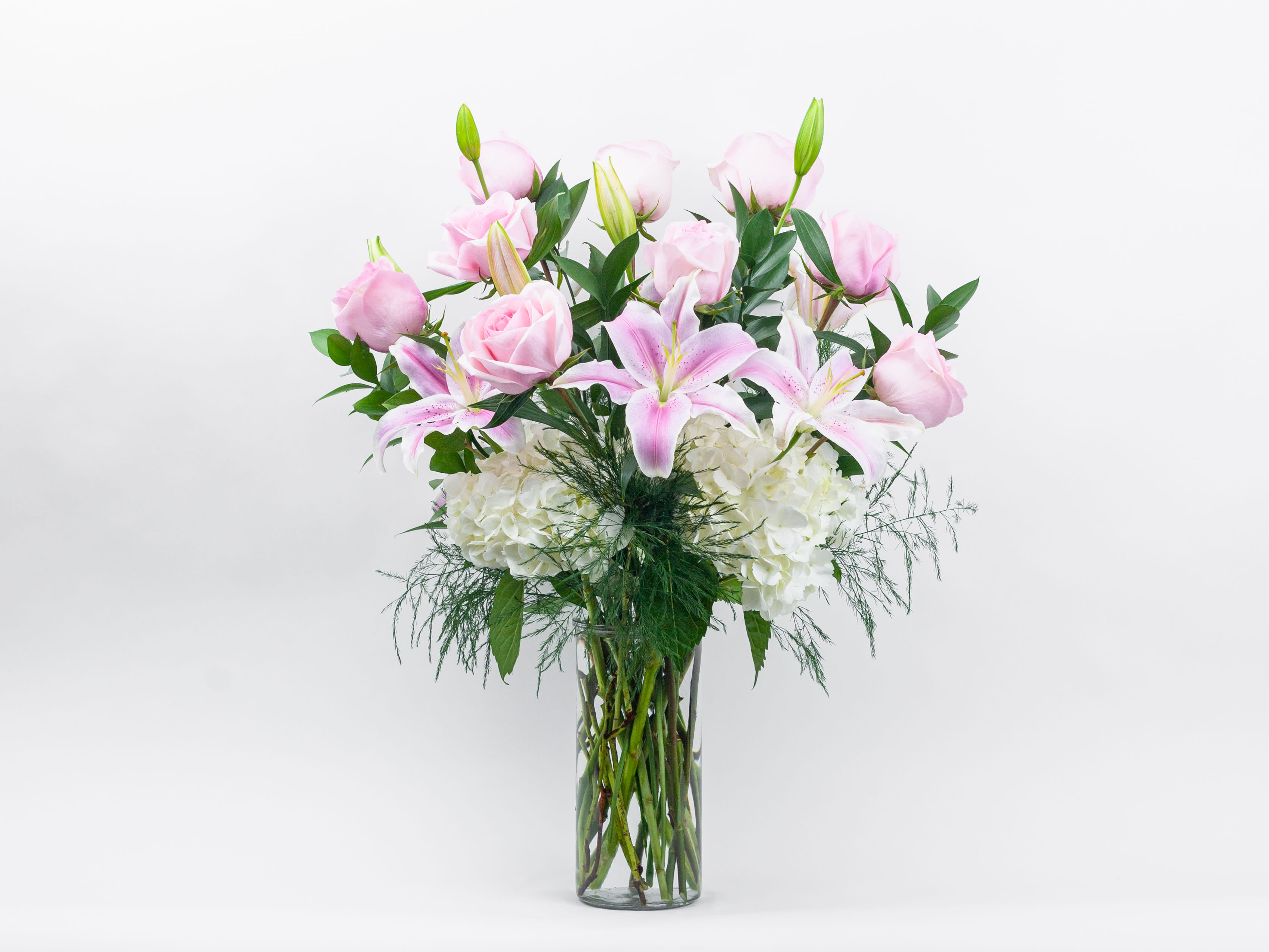 Pink roses and lilies in a clear glass vase