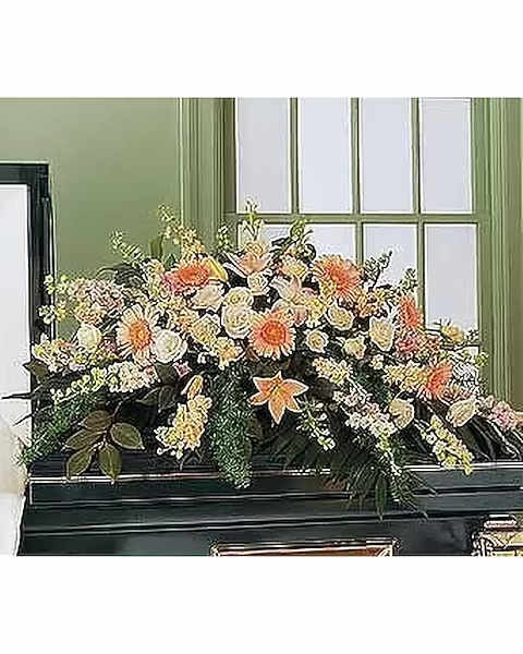 Peach Comfort Half-Couch Spray - Since peach is one of the most naturally comforting colors, this half-couch spray is sure to provide plenty of comfort to all those who care. A half-couch casket spray is delivered decorated with peach gerberas, larkspur, lilies, roses, stock and camellia, along with emerald palm and sprengeri.  