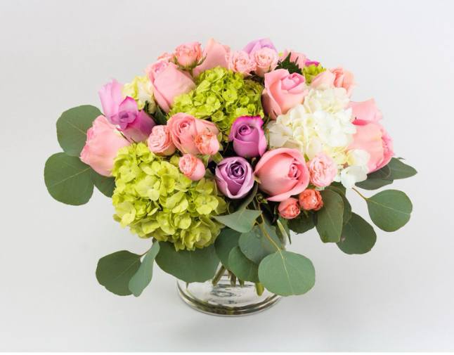 Pink and purple roses with hydrangeas in a glass vase