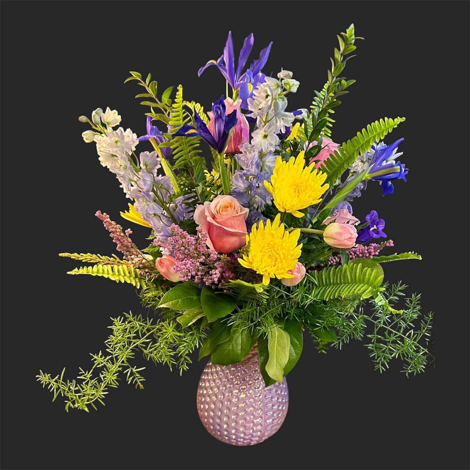 Pastel Radiance Bouquet  - Soft pastel pink roses meet bright yellow chrysanthemums and tall purple delphinium-like spikes in a cheerful mixed-color flower arrangement designed for birthdays, thank-you, or springtime celebrations. The airy, garden-style composition feels fresh and joyful-an easy way to make the person you're thinking of feel seen and celebrated with a playful, feminine touch.