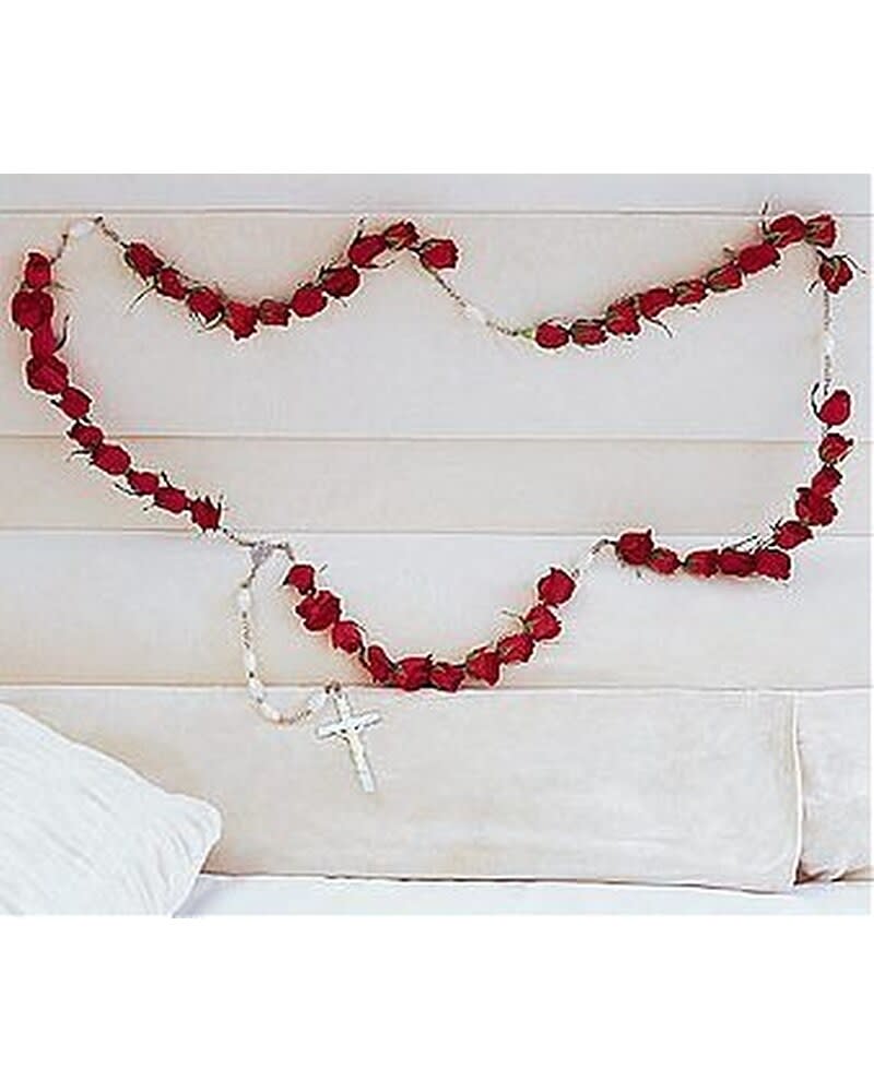 Wall-hung garland of red rose buds shaped like a rosary with white beads and cross
