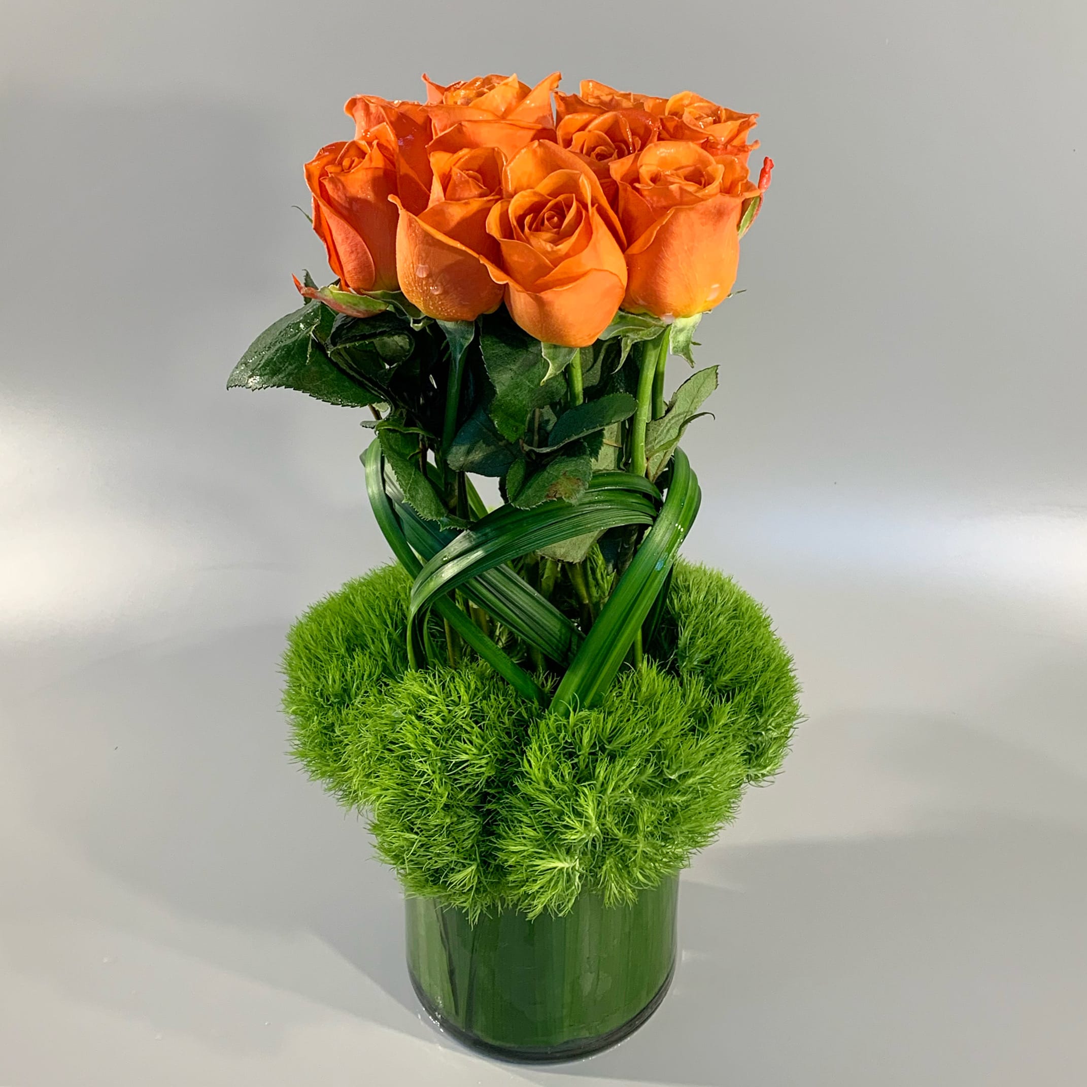 GATHER - An modern gathering of orange roses, finished with sculpted grass and green dianthus.  *You may specify different rose colors: Red, Pink, White or Yellow. 