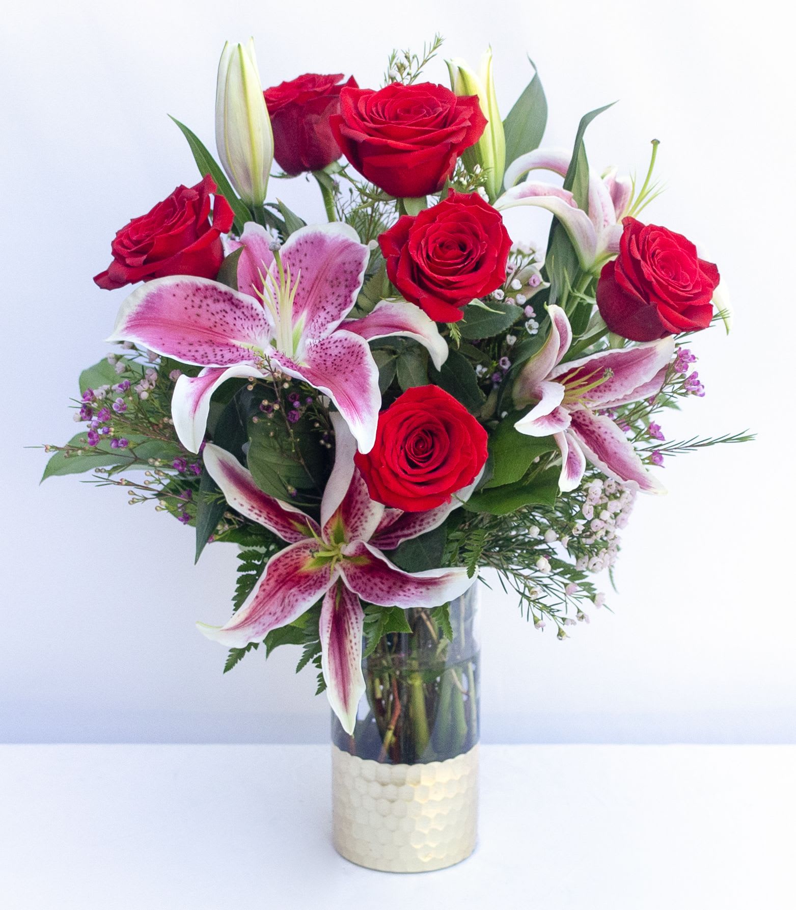 Bouquet of red roses and pink lilies in a glass vase
