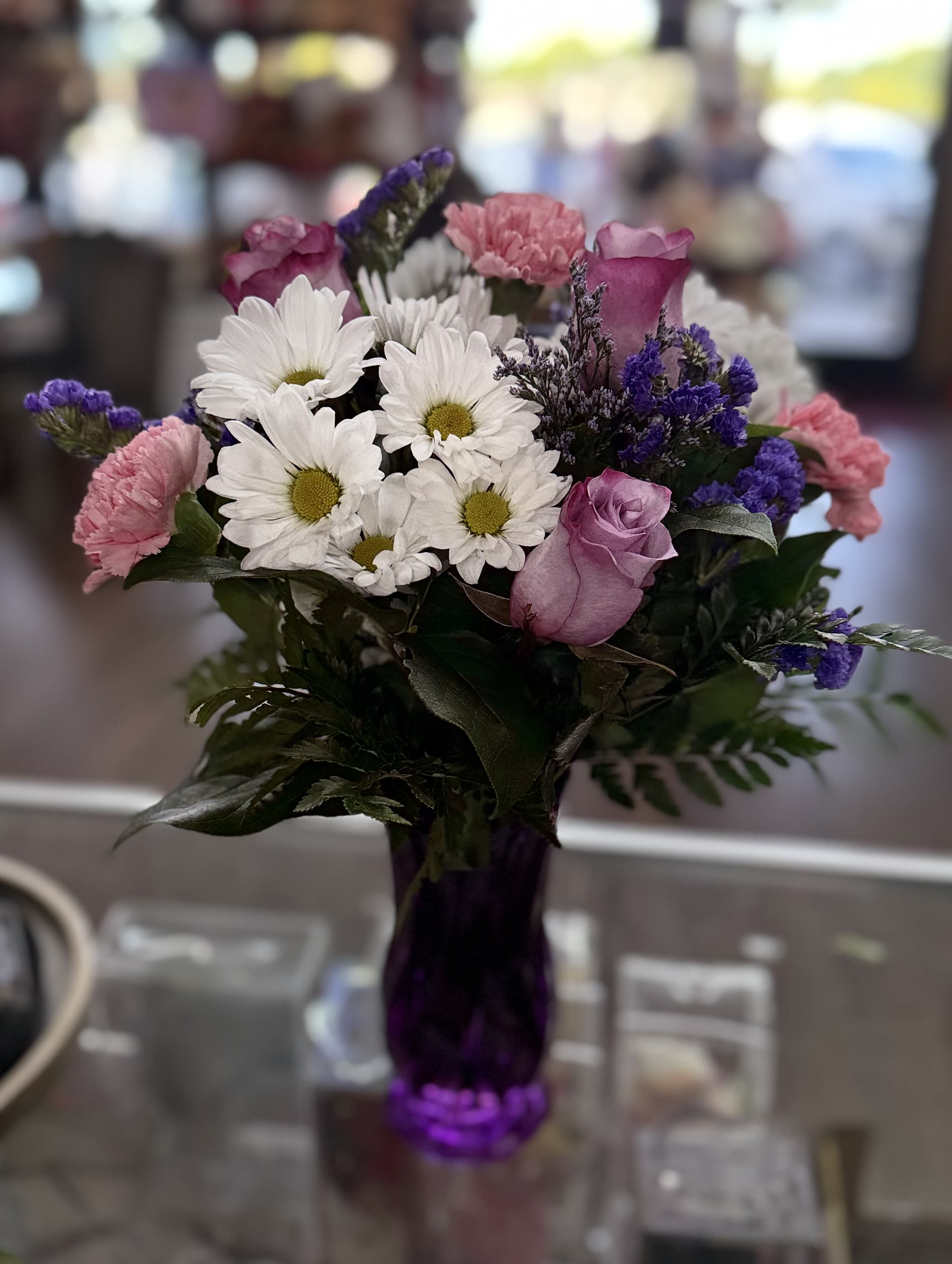 Daisy Delight - A purple vase with roses, daisies, carnations, and purple filler flowers for a flower loving mama. 