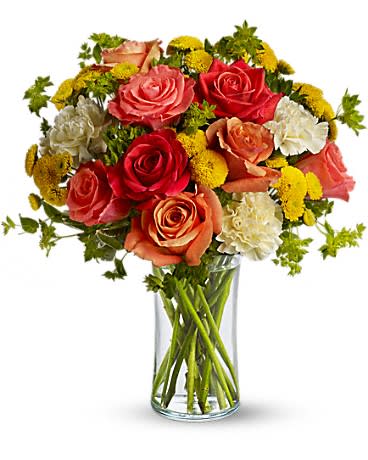 Mixed rose bouquet in a clear glass vase with yellow filler flowers
