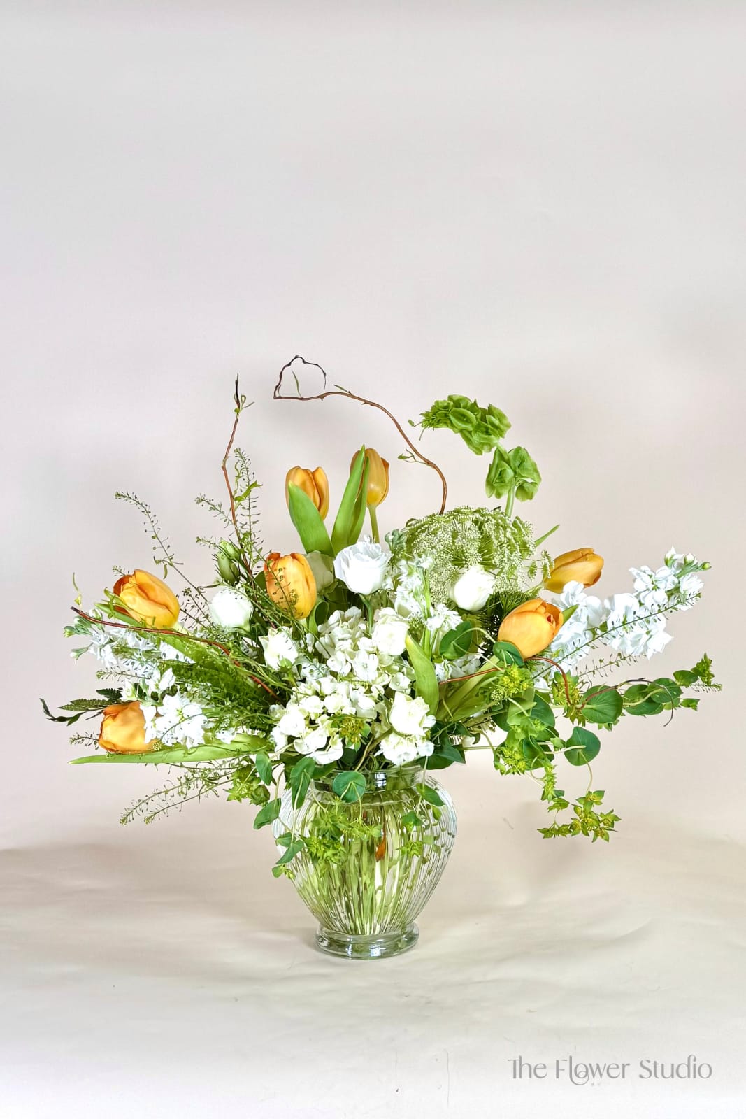 Glden Touch - A fresh and airy arrangement in soft whites and vibrant greens, accented with warm golden tones. Designed with a natural, garden-inspired feel, it brings a sense of lightness and effortless beauty—perfect for celebrating Mother’s Day.