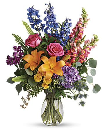 Colorful bouquet with lilies, roses, and snapdragons in a glass vase