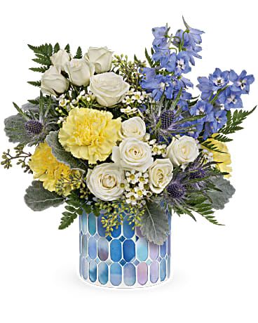 Dreaming of Blue - A refreshing mix of cool blue and sunny yellow, Dreaming of Blue is a cheerful flower arrangement perfect as a birthday bouquet, thank-you gift, or a just-because surprise. The recipient will feel instantly uplifted by the striking contrast of vivid blue delphinium spikes against soft white spray roses-an unexpected color pairing that reads bright, modern, and sincere.  This compact, rounded design pairs creamy white spray roses with bright blue delphinium and cheerful yellow carnations, all cushioned by statice, green buttons and mixed green foliage for texture and movement. The flowers arrive arranged in an iridescent mosaic glass vase that adds decorative shine and contemporary charm while keeping the presentation neat and gift-ready.  Thoughtful for many occasions, Dreaming of Blue is the kind of bouquet that makes someone feel noticed and celebrated-whether you're marking a birthday, saying thanks, or sending a warm hello. Vase is included; to keep blooms fresh, change the water every two days and trim stems slightly when you refresh the vase.