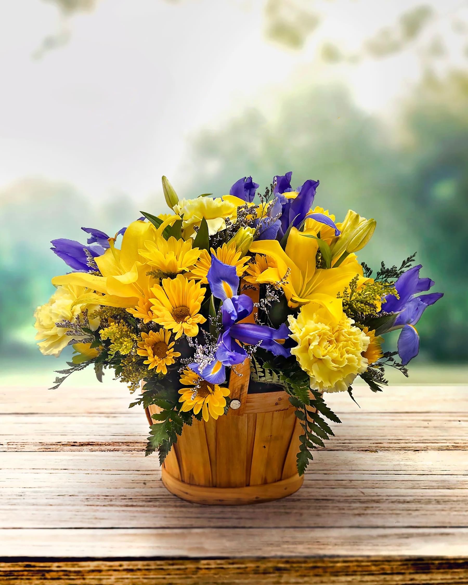 Yellow and purple mixed flower arrangement in a wooden basket