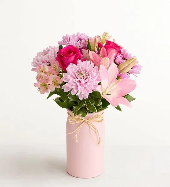 Mother’s Embrace™ Bouquet - Thank Mom for a lifetime of comforting hugs with our Mother’s Embrace™ bouquet. Lovely pink and lavender blooms are hand-designed in a pink ceramic vase, creating a heartfelt expression of your feelings whether you're celebrating Mother’s Day together or sending a smile from miles away. *Vase may vary, depending on availability. 