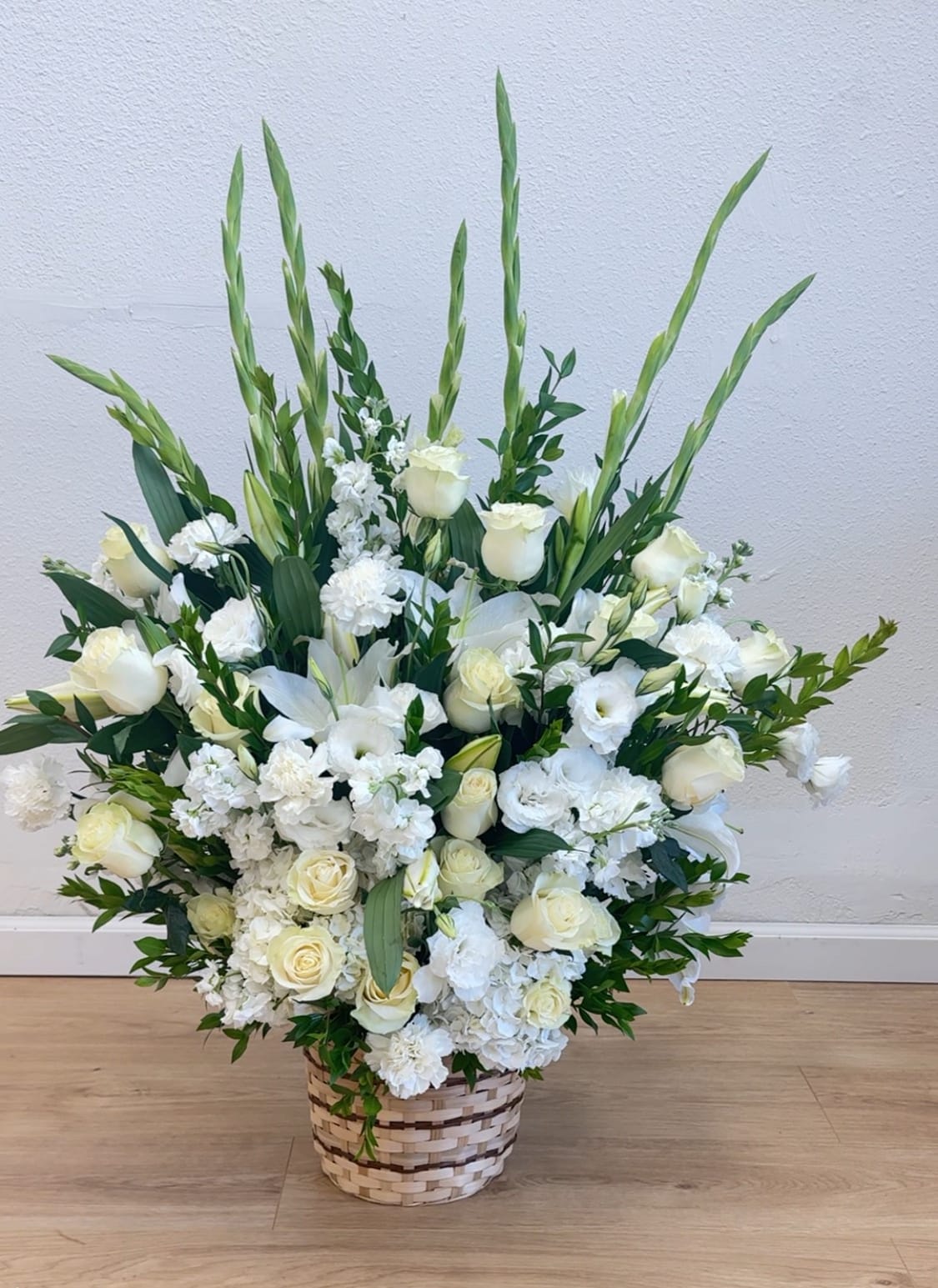 Large white floral arrangement in a woven basket
