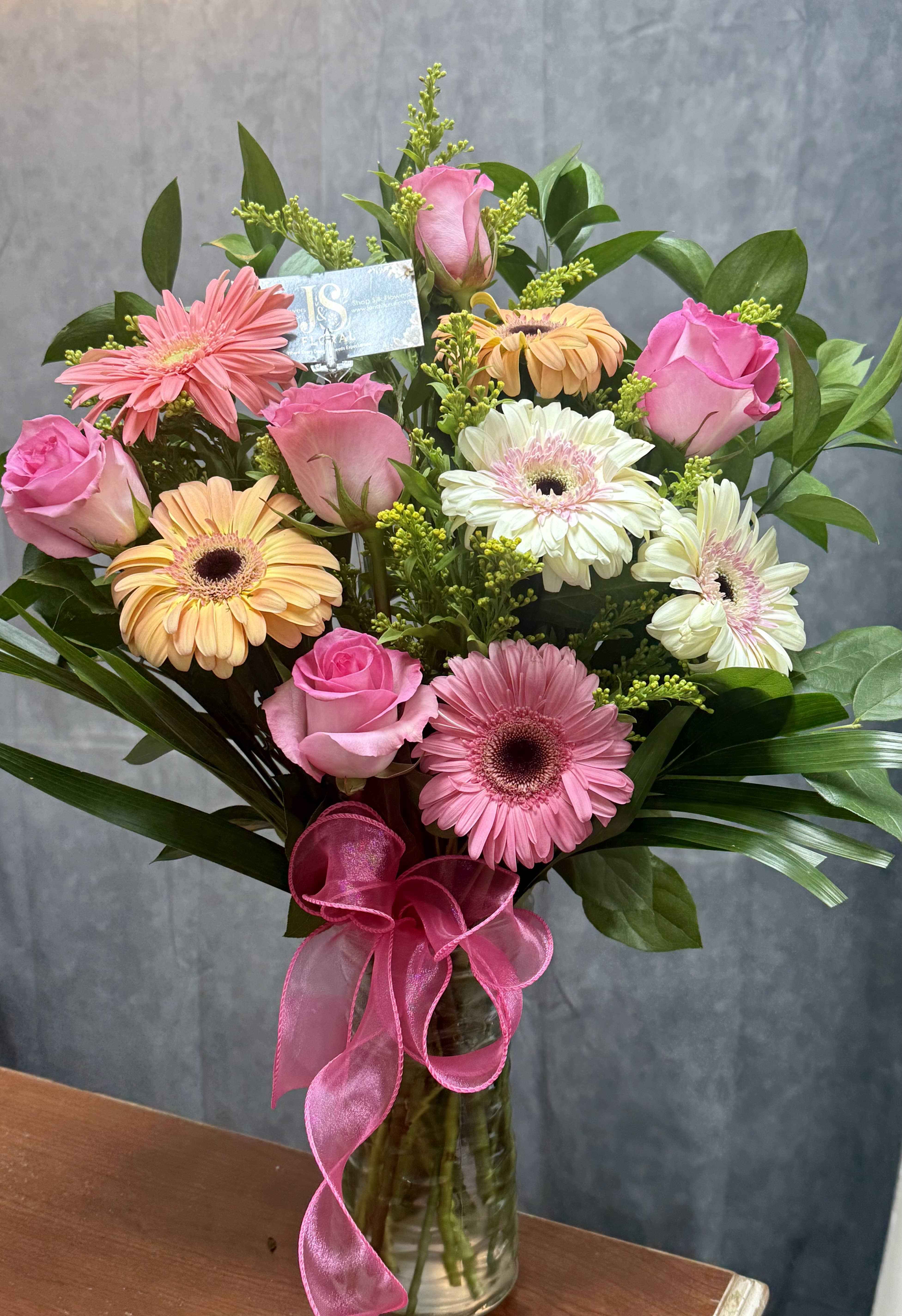 Gerbera Roses lovers  - Pink roses and mix colors gerbera daisies with greenery beautifully arranged in a vase, tied with a beautiful ribbon-cheerful, perfect for birthdays, thanks you , or spring celebrations.