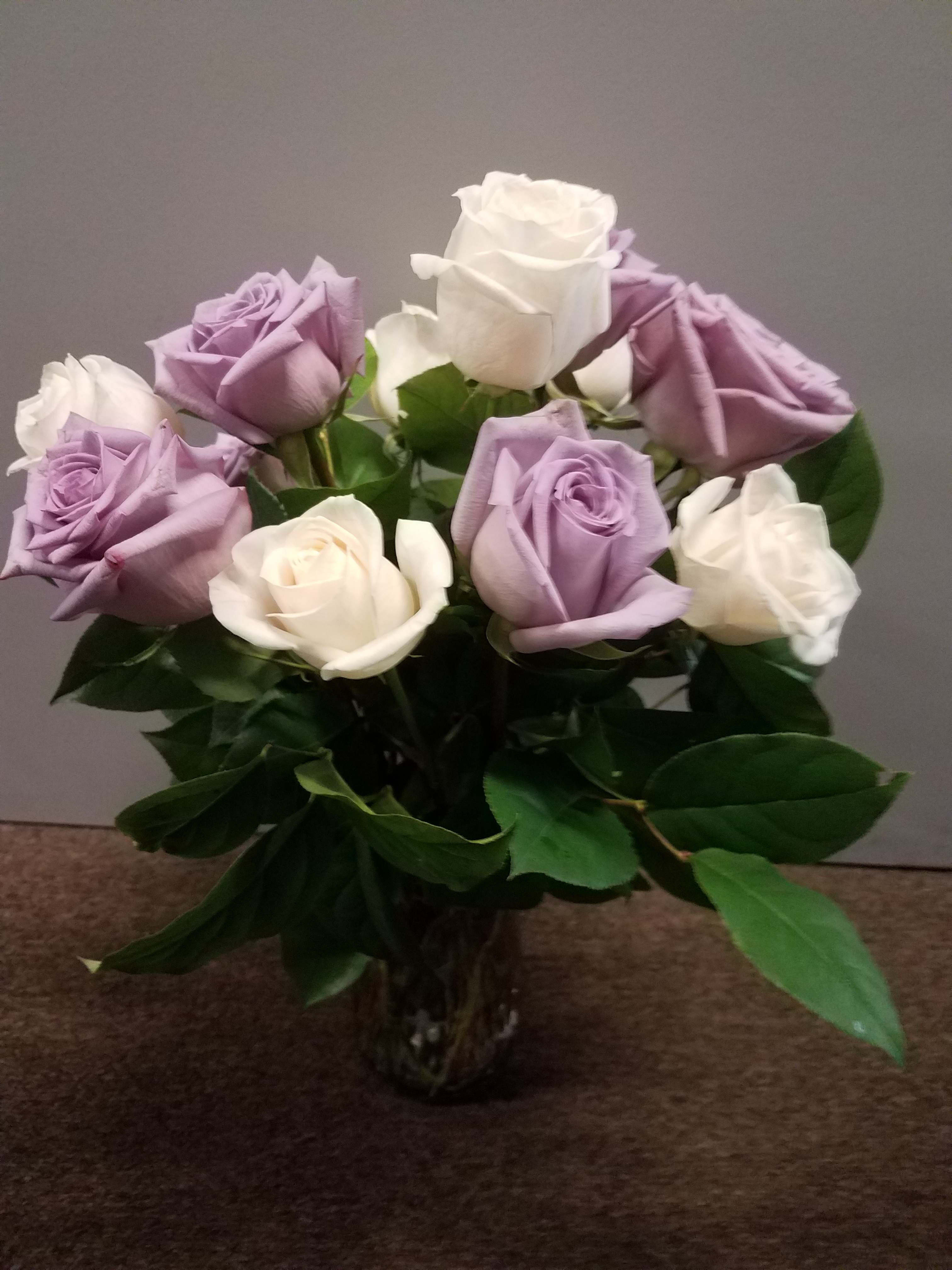Bouquet of lavender and white roses in a clear glass vase