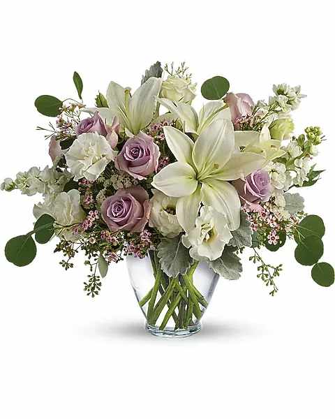 Lovely Luxe Bouquet - Pamper your lovely with this luxurious lavender and cream bouquet! Ravishing roses, fragrant lilies and delicate lisianthus create a chic, sweet surprise they'll never forget. Lavender roses, white asiatic lilies, white lisianthus, white stock, lavender waxflower, and white sinuata statice are accented with dusty miller, seeded eucalyptus, and silver dollar eucalyptus. Delivered in a serenity vase.  