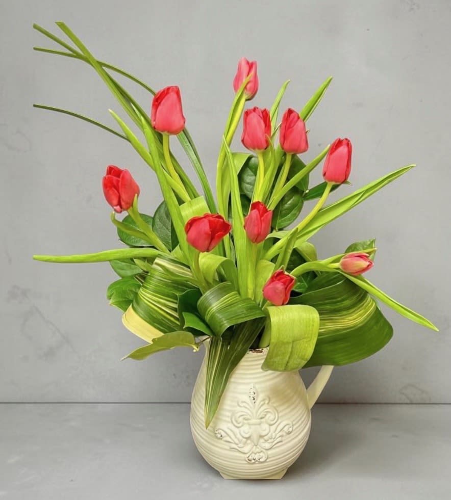 Pitcher of Tulips - A spray of tulips with long, arching green leaves creates a fresh, lively statement - perfect as a spring bouquet, housewarming gift, or casual thank-you arrangement. This flower arrangement of tulips is arranged in a cream-colored ceramic pitcher, so the recipient gets the double delight of living blooms and a charming vase they can reuse long after the flowers fade.