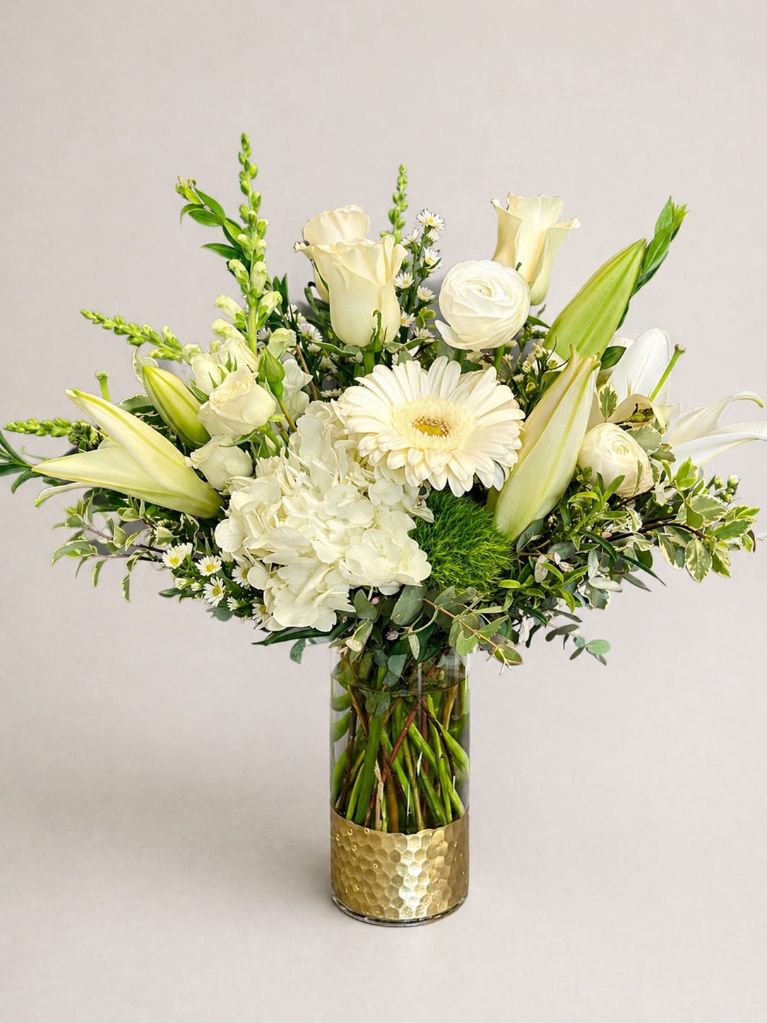 Quiet Comfort  - White lilies and airy hydrangea create a quietly elegant statement in this flower arrangement perfect as a sympathy piece or a refined anniversary bouquet. Quiet Comfort blends white, soft yellow, and green tones to give the recipient a sense of calm and care; its tall, lifted silhouette and delicate daisy-like accents read as both fresh and formal, ideal for Mother's Day, weddings, or those moments when you want to say "I'm thinking of you" with grace
