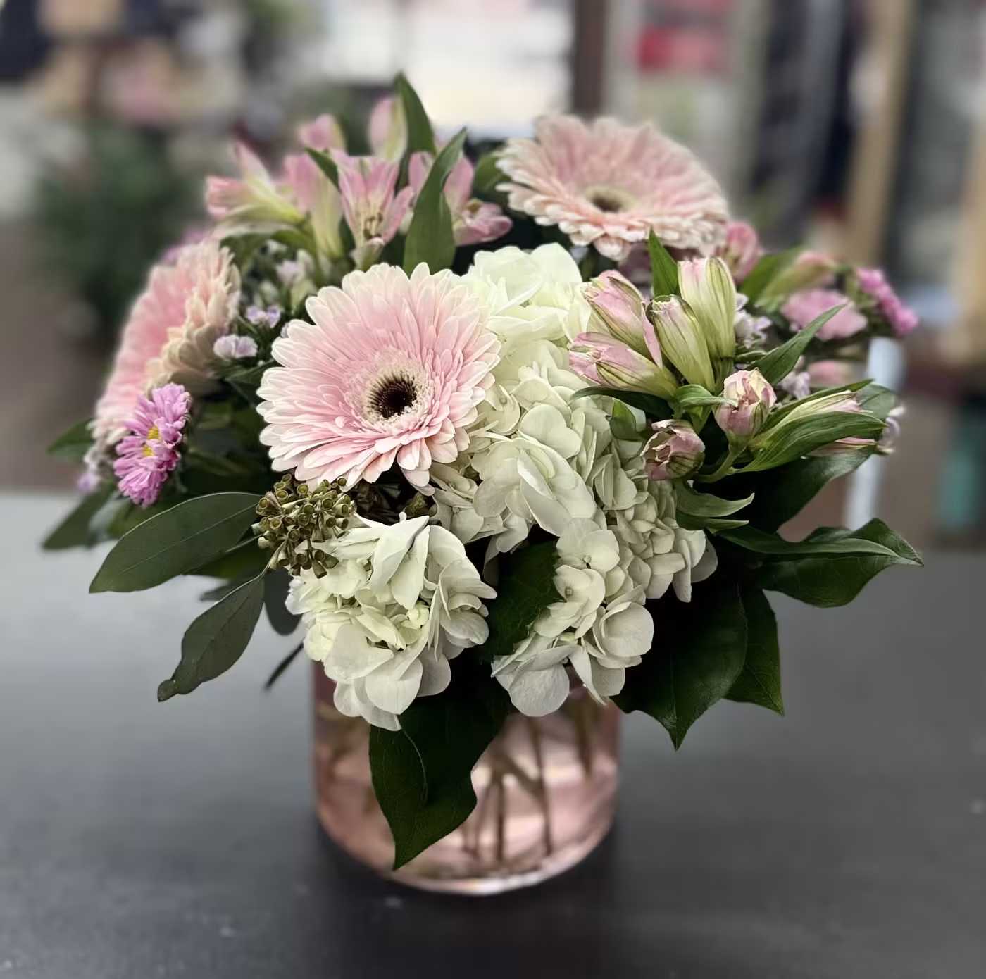 Blush &amp; Beyond - Pale pink gerberas, white hydrangeas, soft alstroemeria and asters arranged in a rose-gold glass vase.  