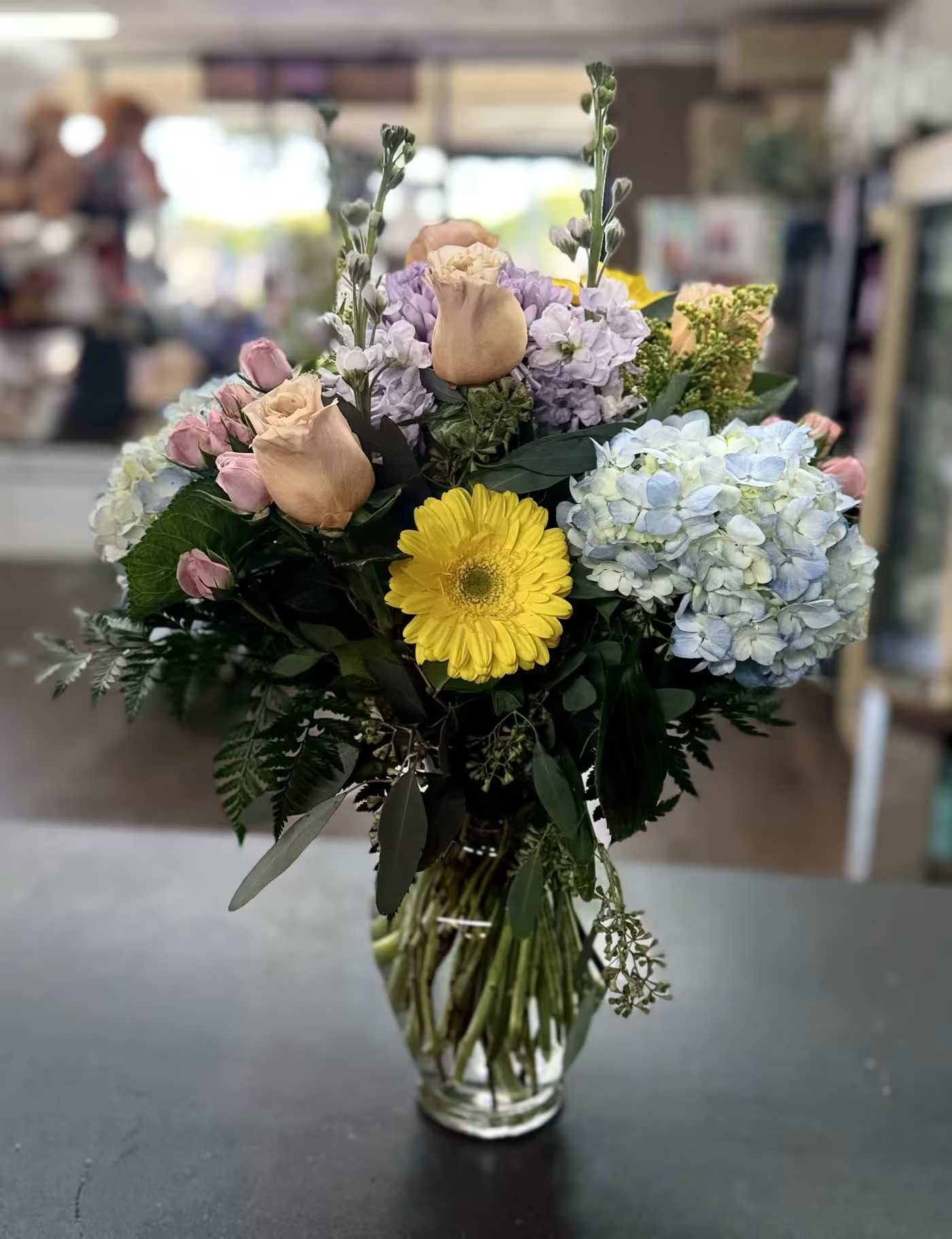 The Queen's Garden - Clear glass vase bouquet with hydrangeas, roses, gerbera daisies and spray roses in mixed pastels  