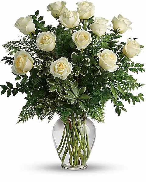 Joy Of Roses Bouquet - A joyful gesture of love and affection, this chic arrangement of one dozen pure white roses with fresh greens is a special surprise on any occasion. Exquisite 12 Roses Elaborate 18 Roses Extraordinary 24 Roses 12 white roses are arranged with leatherleaf fern, huckleberry and variegated pittosporum. Delivered in a clear vase.  