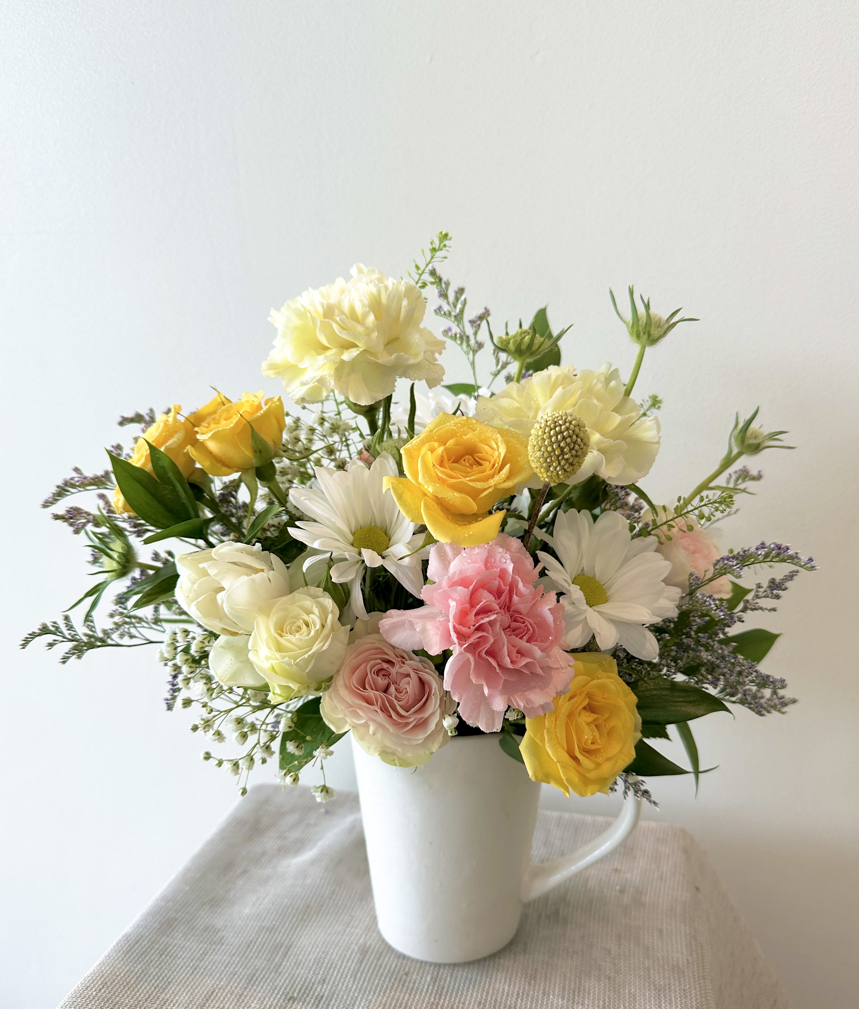 Mixed florist choice in a cup - A beautiful mixed florist choice of the freshest flowers to make your loved one smile.