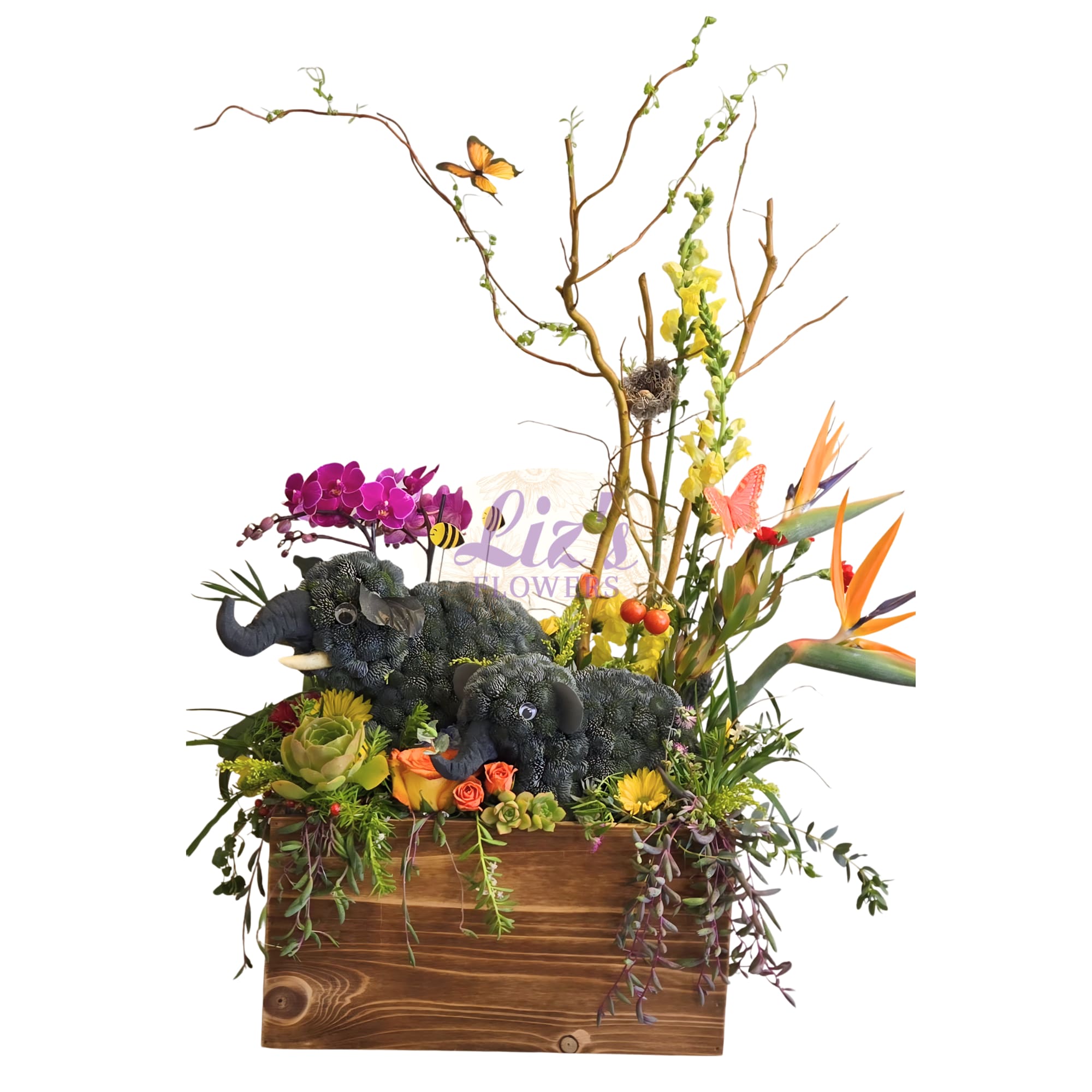 The Enchanted Elephant Oasis - A breathtaking masterpiece of botanical artistry, this one-of-a-kind installation features a hand-sculpted moss elephant family nestled in a lush, living landscape. This premium design is overflowing with exotic Phalaenopsis orchids, vibrant Birds of Paradise, and a diverse collection of rare succulents. Tall, natural branches reach upward to host delicate butterflies, honeybees, and a bird’s nest, creating a 360-degree story of nature’s beauty.