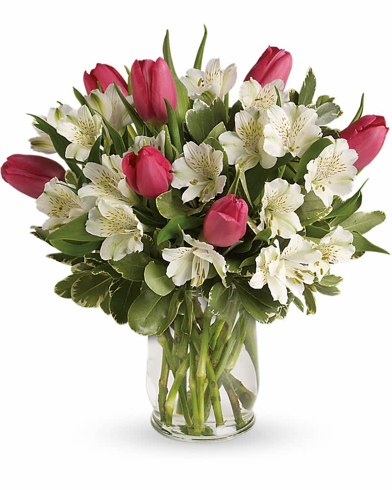 Pink tulips and white alstroemeria arranged in a clear glass vase