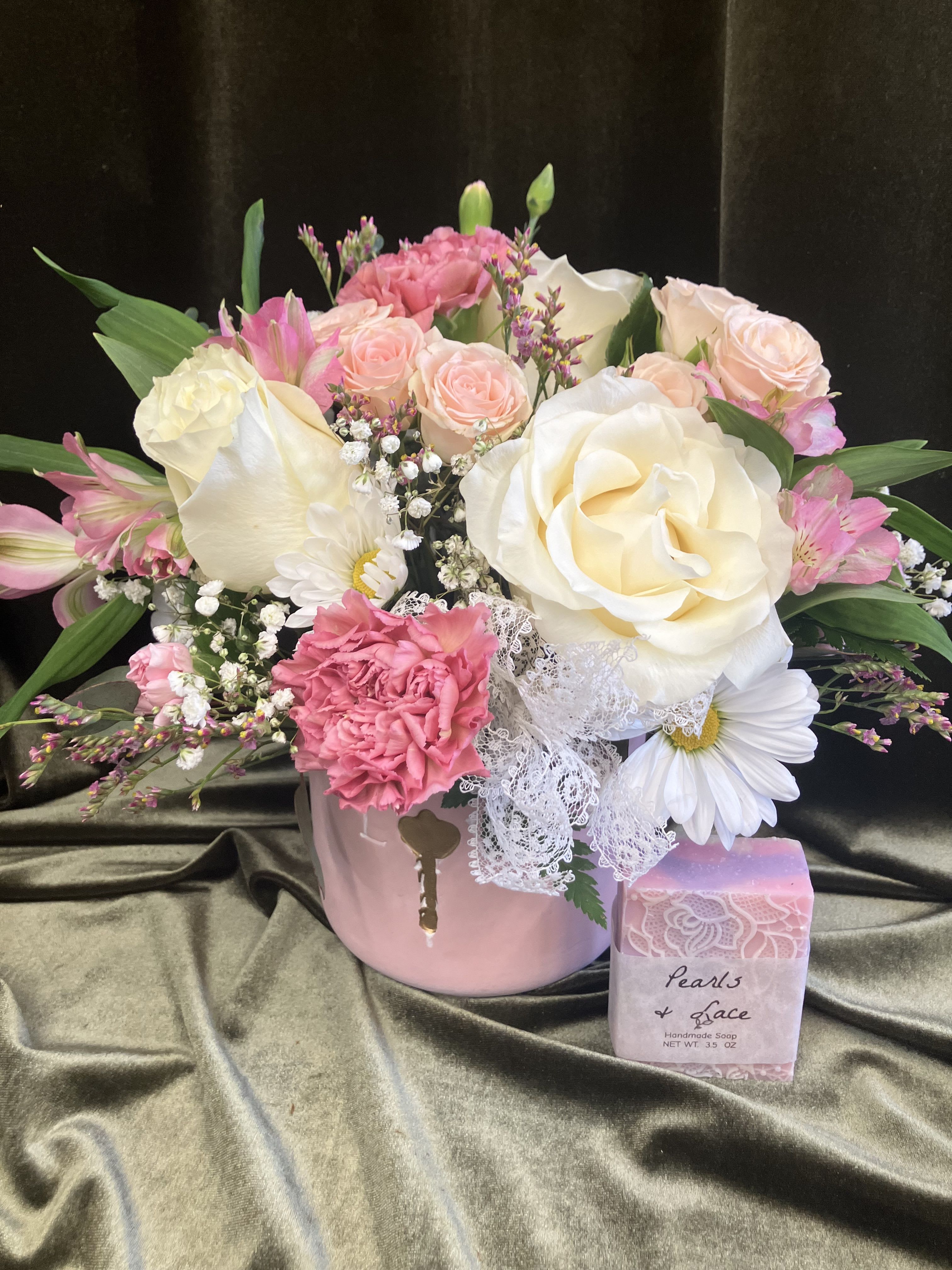 Cute Pink and White  - Soft pink ceramic container with white roses, pink carnations, alstroemerias and pink and white fillers and lace ribbon. Paired with a pretty locally made soap 
