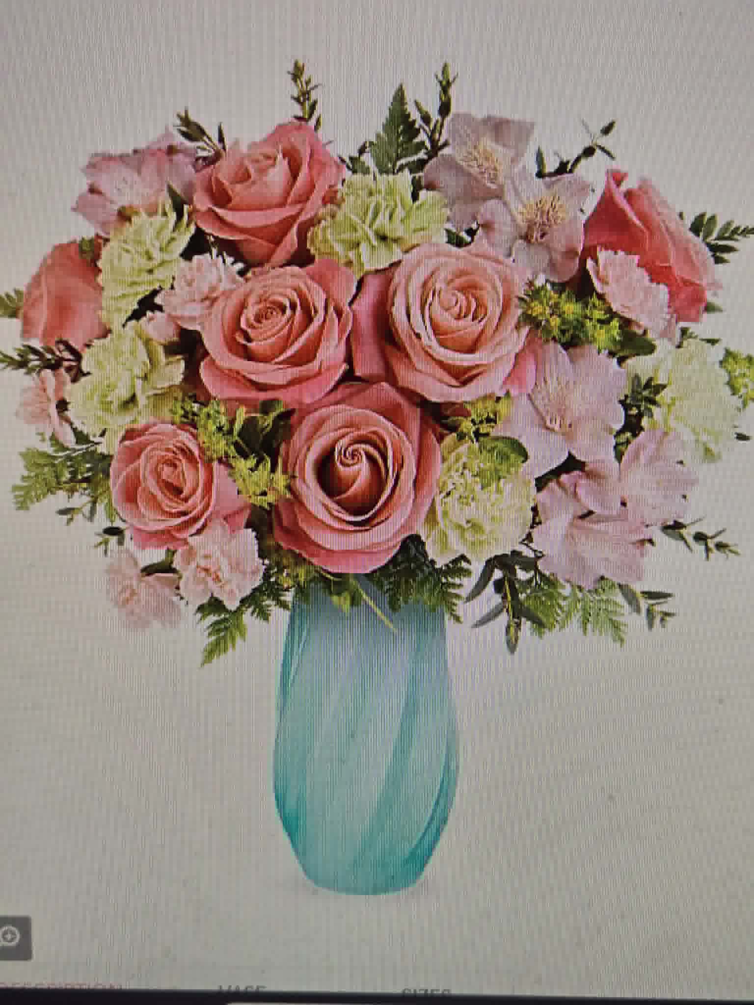 Morning in the Garden - A lush cluster of pink roses and pale carnations forms the heart of this birthday bouquet, a feminine, celebratory arrangement that reads soft and romantic the moment she sees it. The rounded, full shape and creamy filler blooms give the person you're thinking of an instant feeling of being cherished-perfect for anniversaries, Mother's Day, or any milestone that calls for a tender, joyful surprise.  Mixed roses and carnations in shades of blush, pale pink, and cream are woven with small green sprigs and delicate accent stems for texture and movement. The flowers are presented in a tall turquoise glass vase that makes the pinks pop with a cool, modern contrast and elevates tabletops or mantel displays. This design arrives ready to enjoy; for best results, keep the vase topped with fresh water and trim stems every few days to extend the life of the arrangement.
