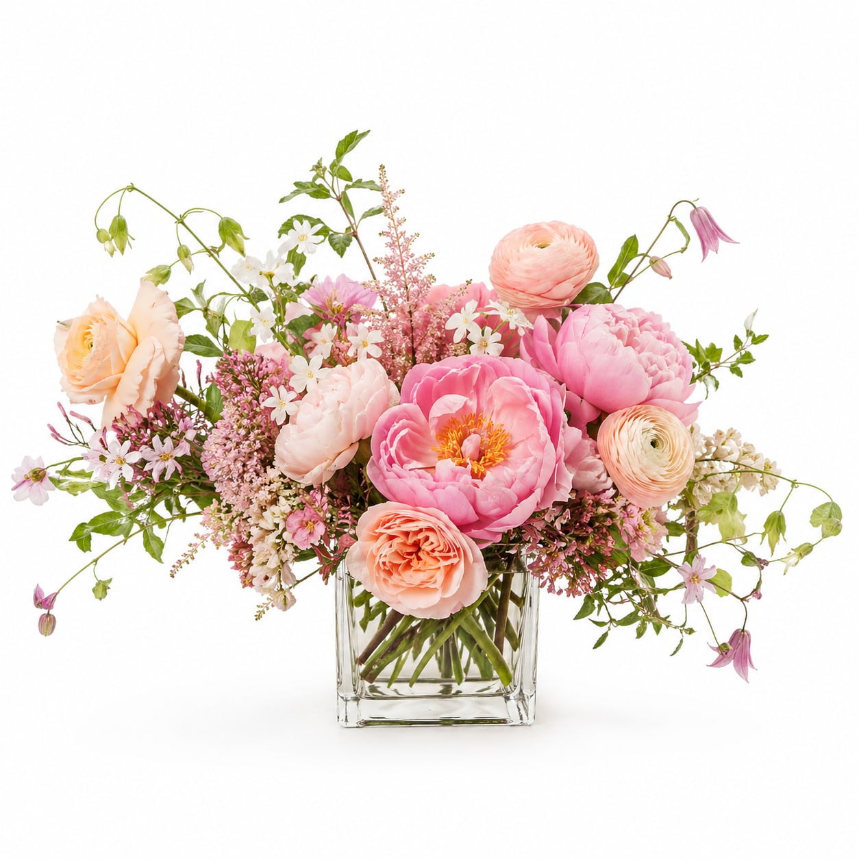 Peaches &amp; Cream Peony Cube - A soft, whimsical garden-style arrangement featuring lush peonies in blush and pink tones, accented with romantic roses and delicate seasonal blooms in a clear glass cube