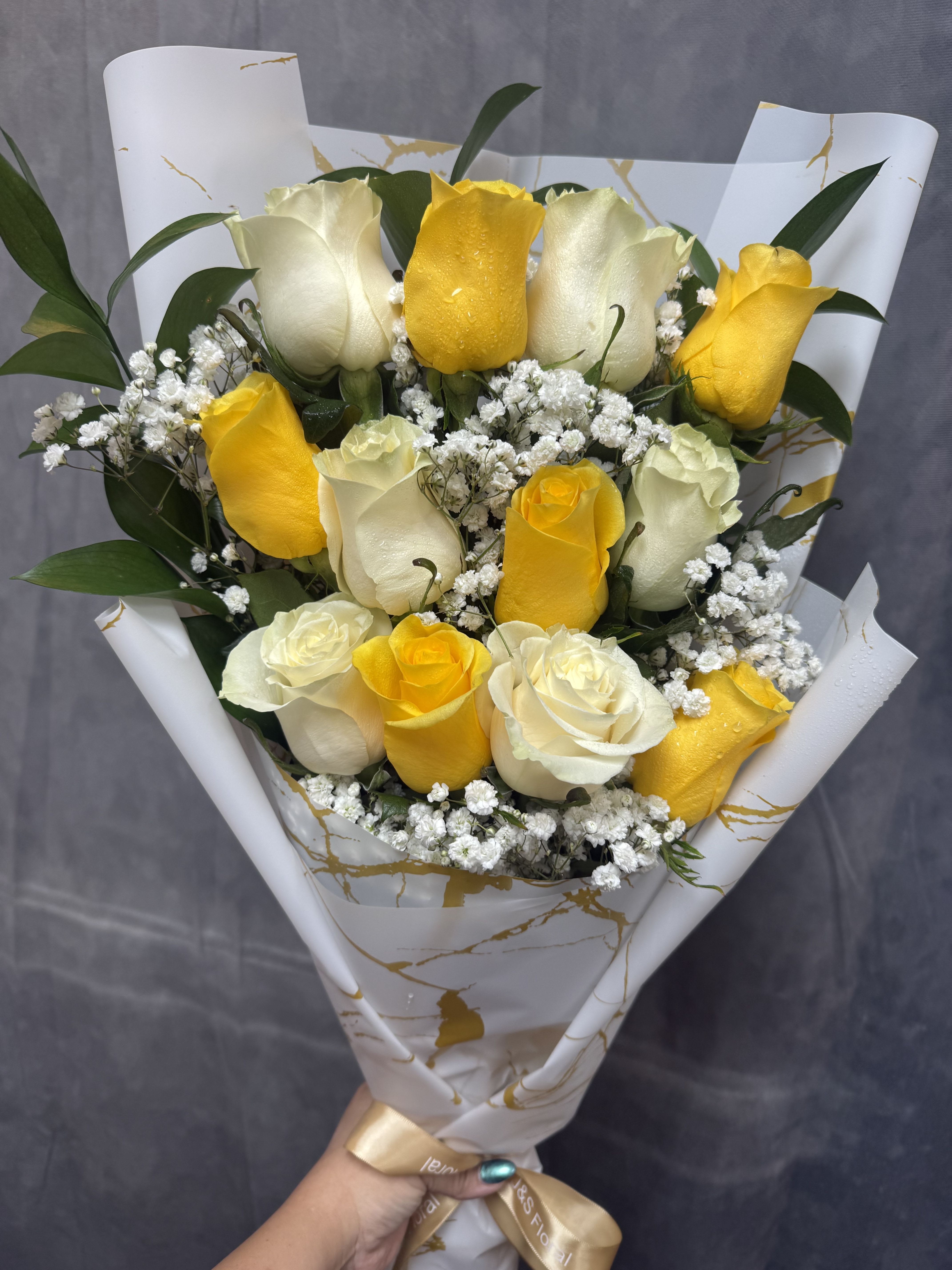 Yellow and white roses layered bouquet  -  Bright yellow and soft white roses with green foliage, beautifully wrapped in paper and satin ribbon-cheerful, polished bouquet perfect for birthdays, congratulations, or a thoughtful everyday gift.