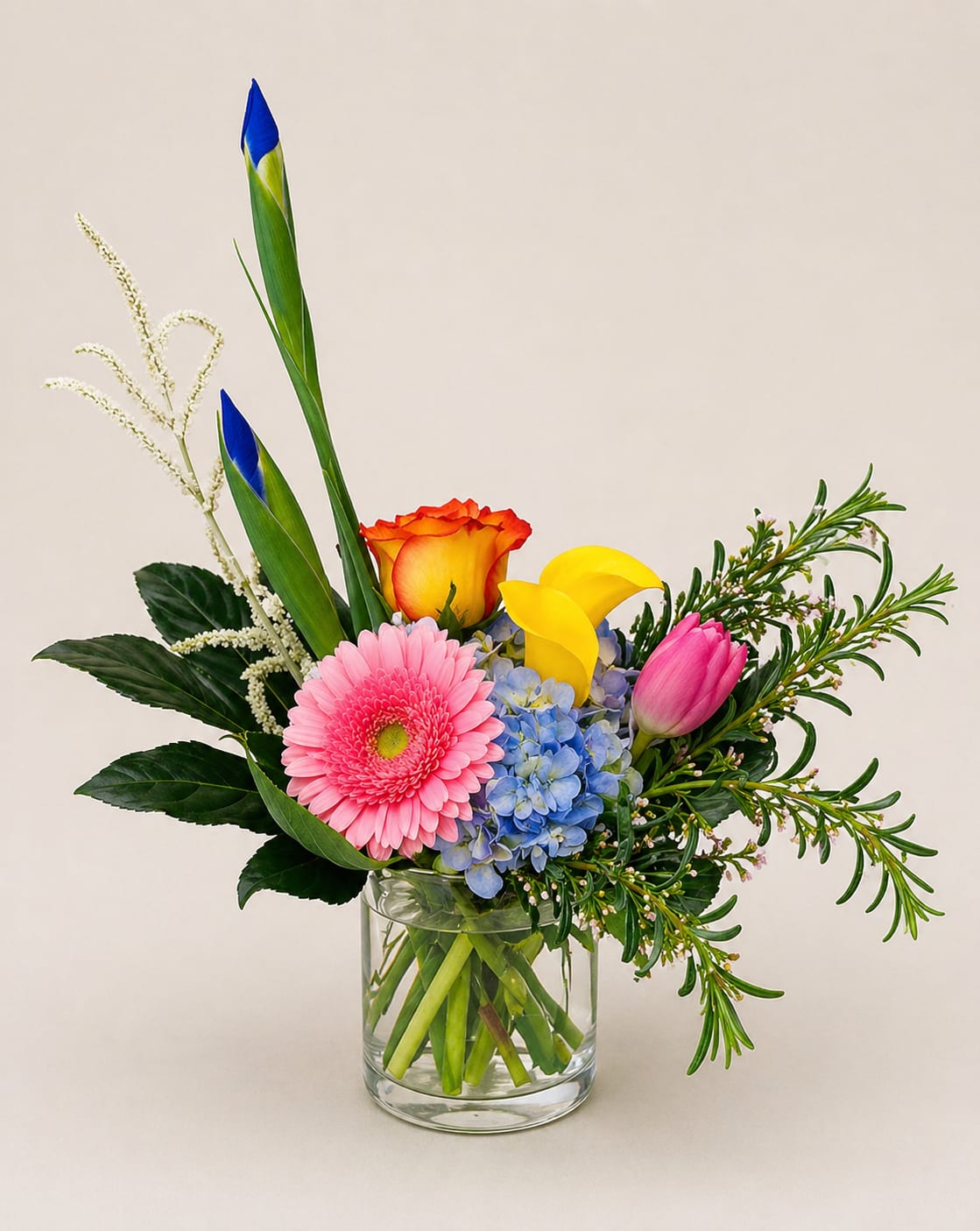 Spring Fling  - A vivid, modern mixed bouquet that reads like a spring celebration - perfect as a Mother's Day gift, an anniversary surprise, or a "just because" pick-me-up. The Spring Fling flower arrangement pairs bright pink gerbera daisies and pink tulips with sunny yellow calla lilies and warm orange-red roses, anchored by vivid blue hydrangea for striking contrast. Designed to make the recipient feel seen and celebrated, it's an energetic, joyful choice for thank-you moments or to mark birthdays and congratulations.