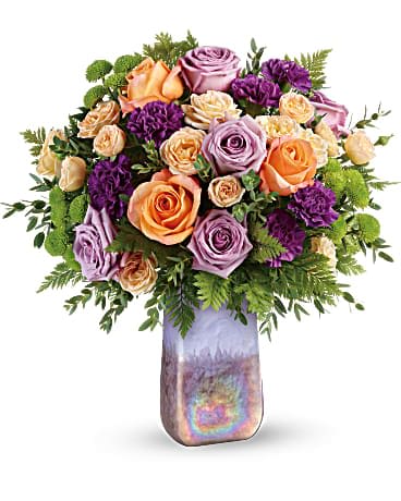Bouquet of peach, lavender, and purple roses in a iridescent vase