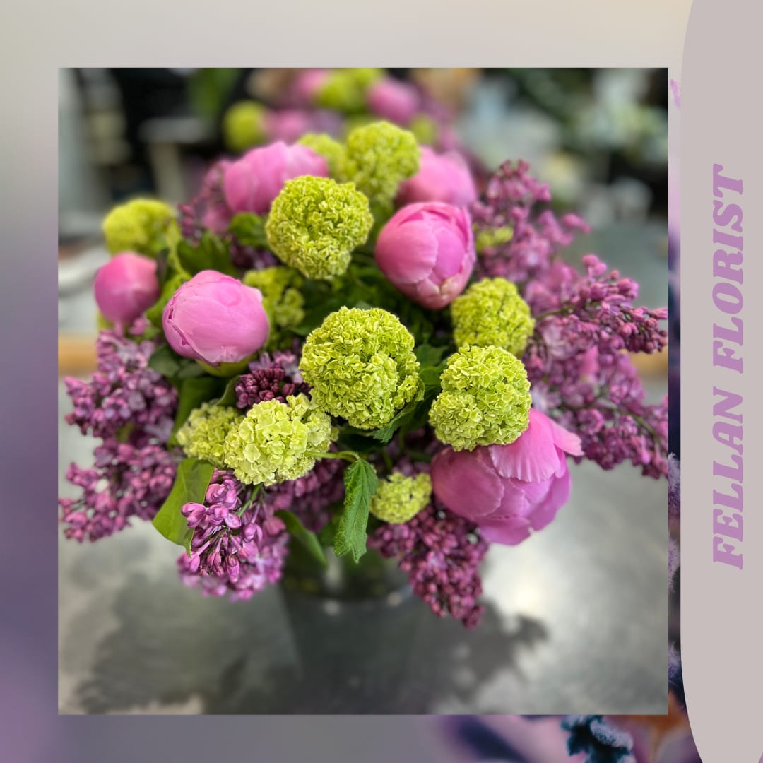 Mía - beautiful seasonal arrangement with peonies and viburnum in a beautiful glass vase with a leaf inside, makes this arrangement an elegant detail to give as a gift