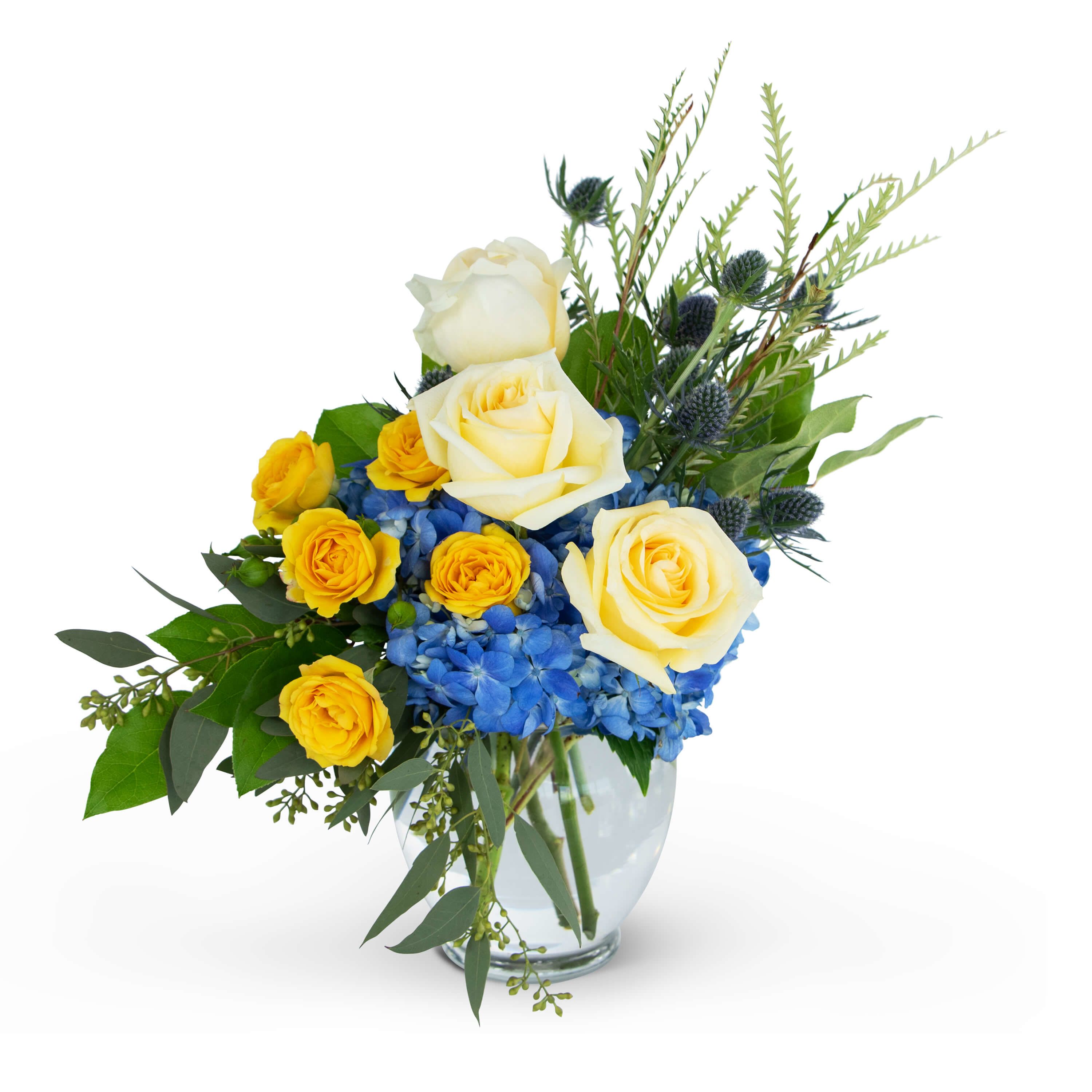 Land and Sky - Apart, they are each a masterpiece. Together, they are breathtaking.  The Land and Sky arrangement brings together nature's boldest colors to bring you a glimpse of what happens when two forces collide. Creamy Yellow Roses, Blue Hydrangea, Bold Yellow Spray Roses and Thistle are combined to create this modern design. This burst of color is perfect for any occasion.Approximately 9"W X 15"H