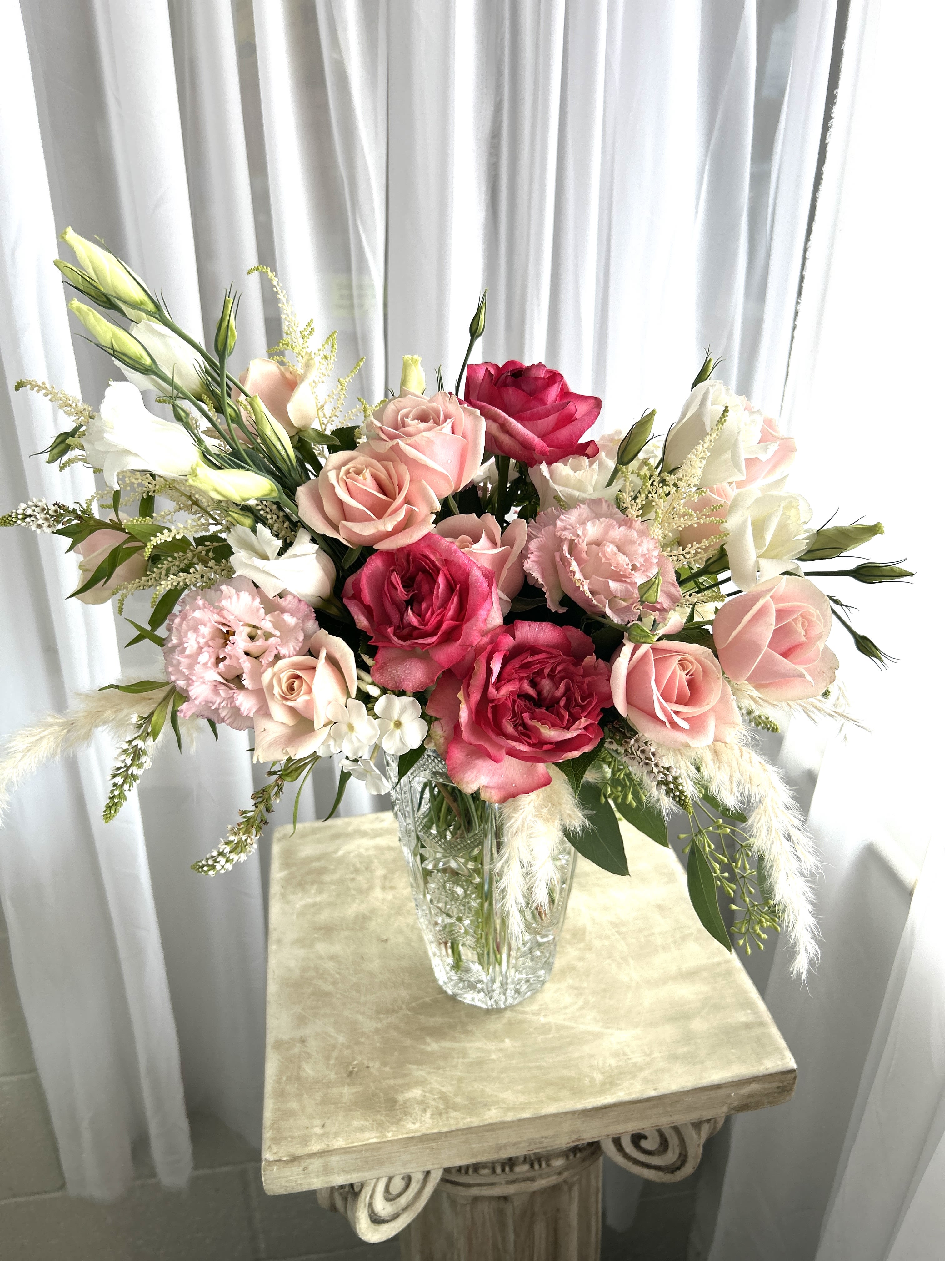 Pink and white rose bouquet in a clear glass vase